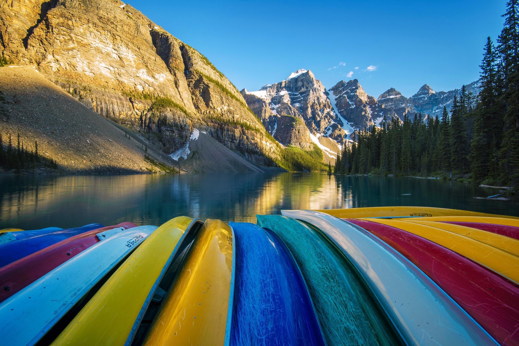 Colorful canoes on a lake with mountains HD Wallpaper