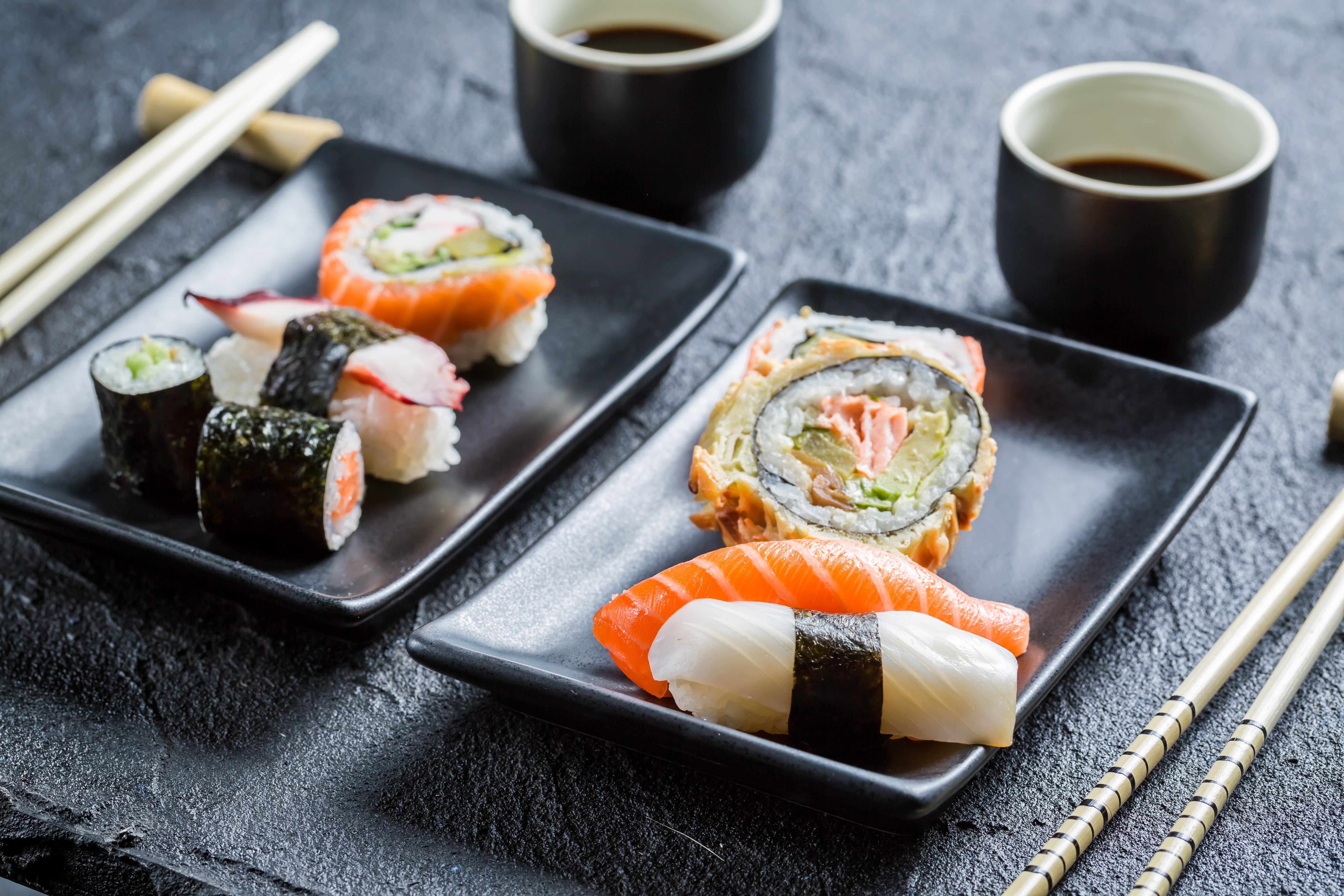 Sushi on black plates with soy sauce HD Wallpaper
