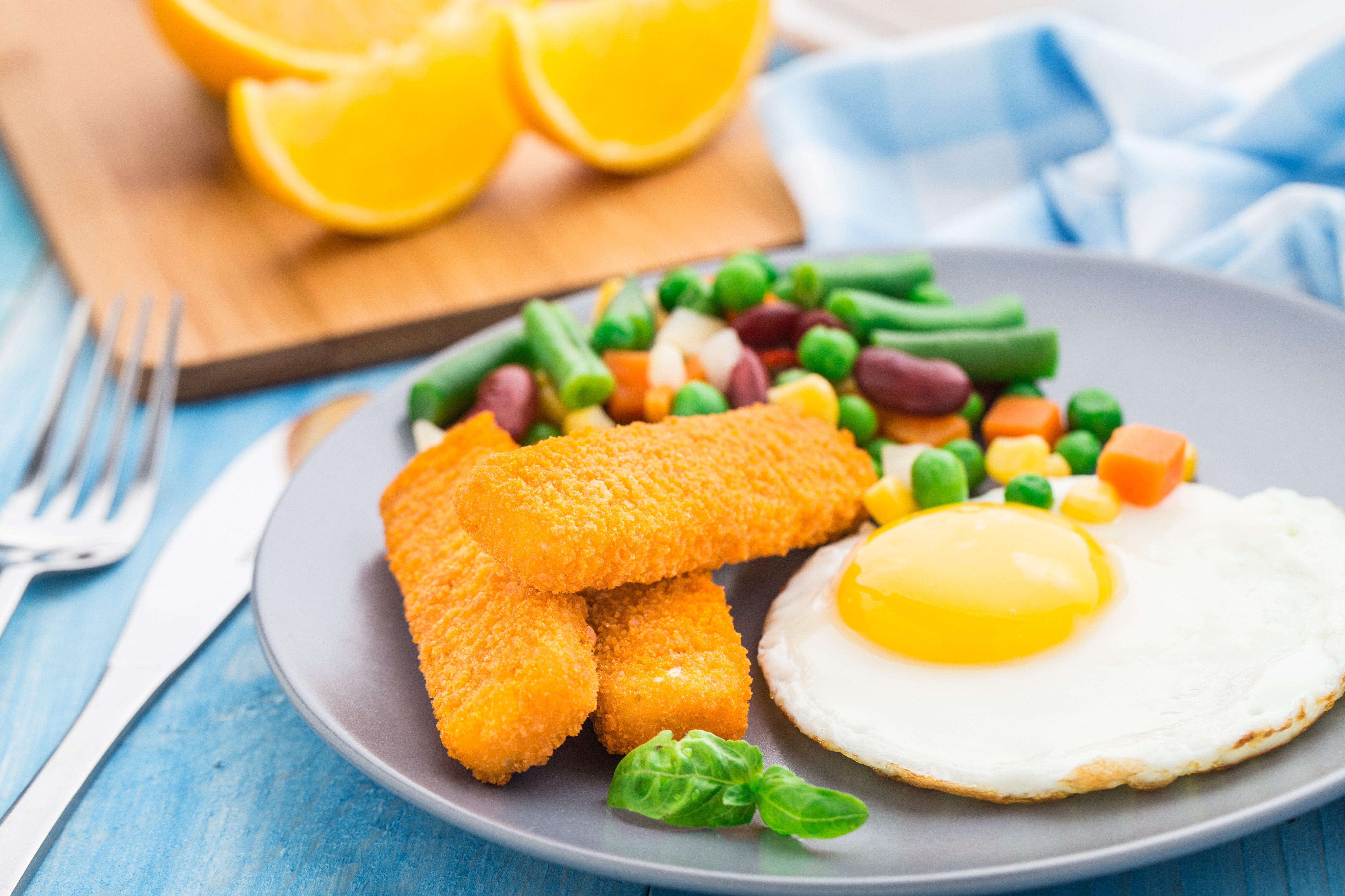 Fried egg with fish sticks and vegetables on a plate HD Wallpaper