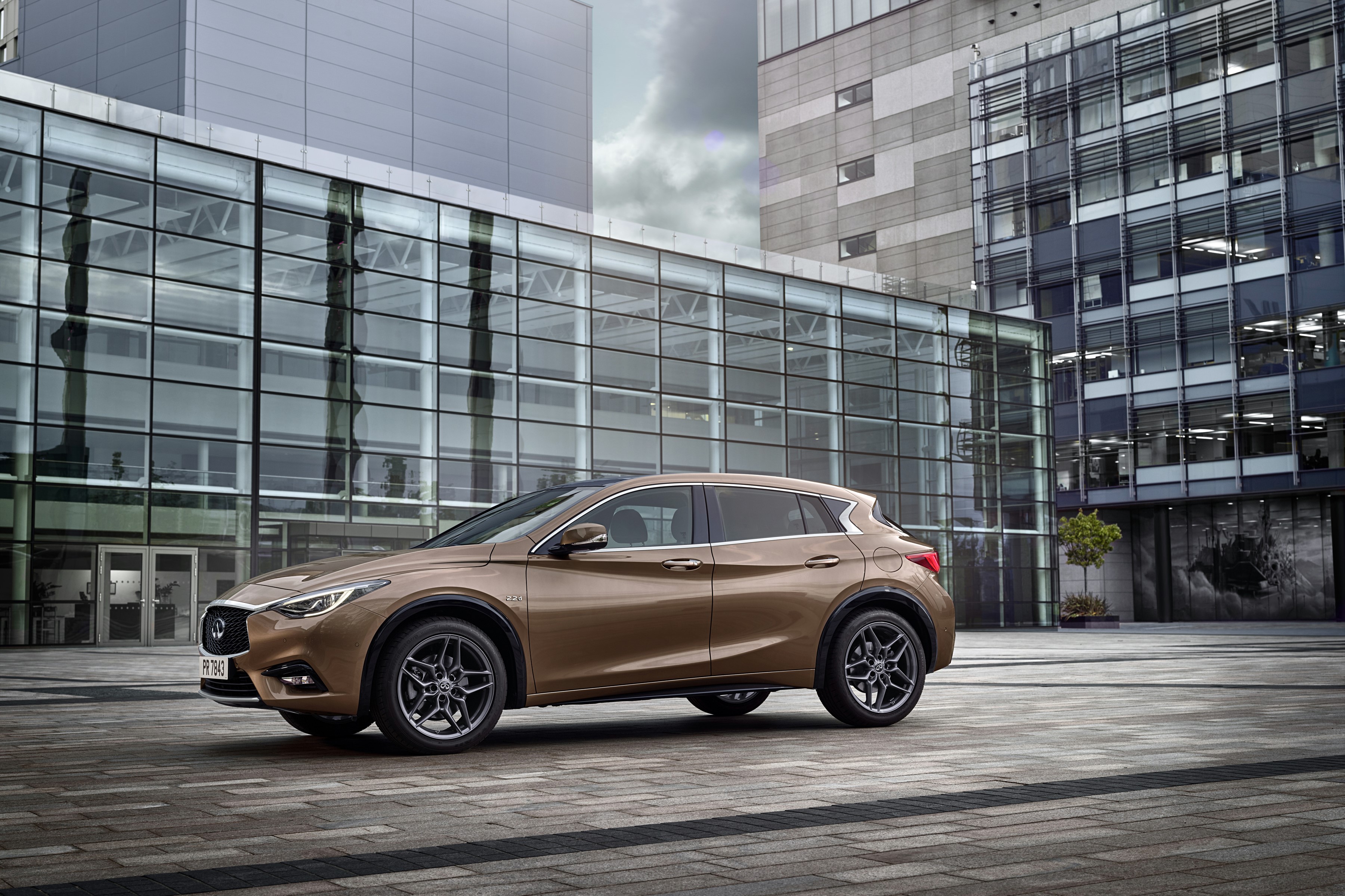 2015 Infiniti Q30 parked in front of modern buildings HD Wallpaper