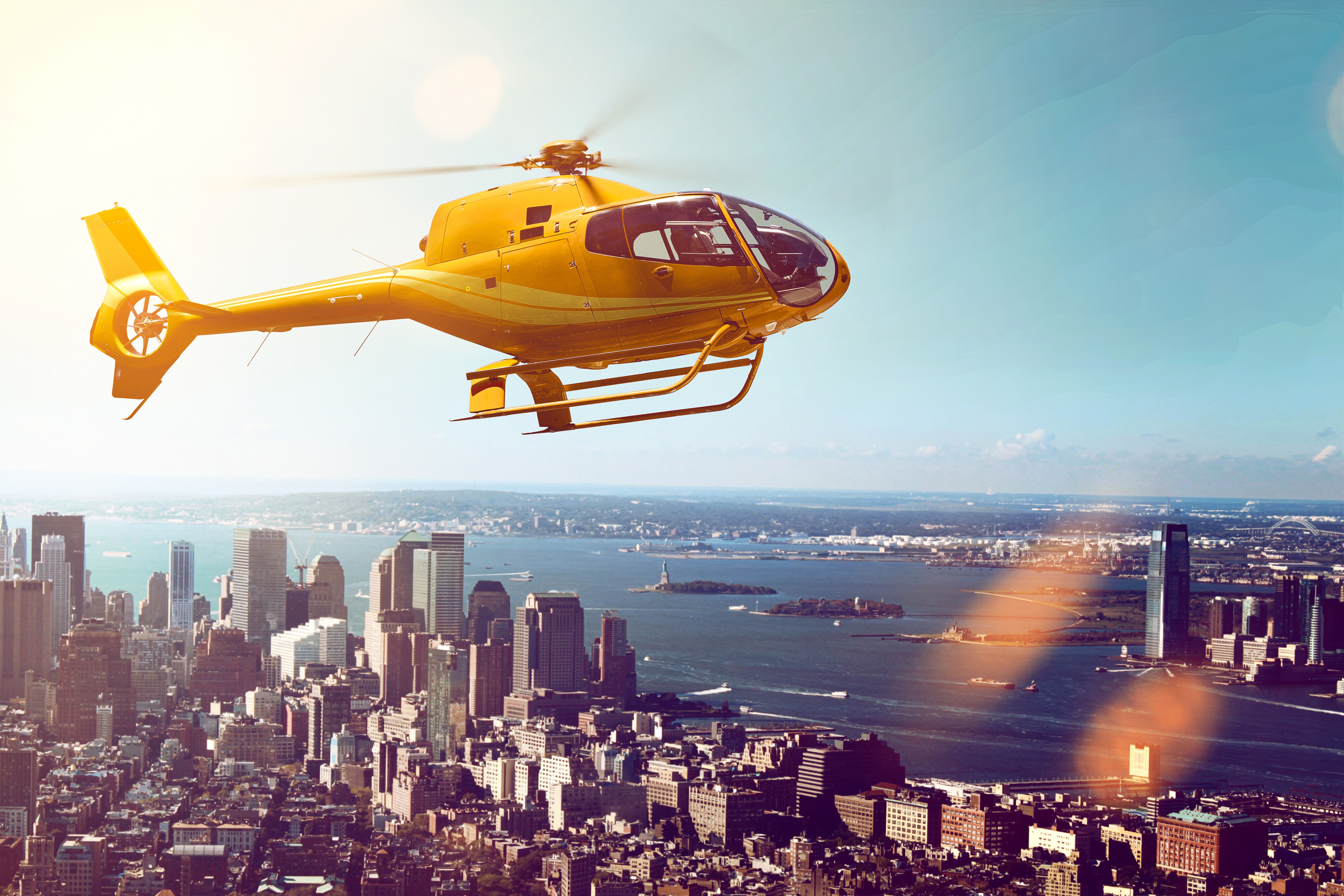 Yellow helicopter flying over New York City skyline HD Wallpaper