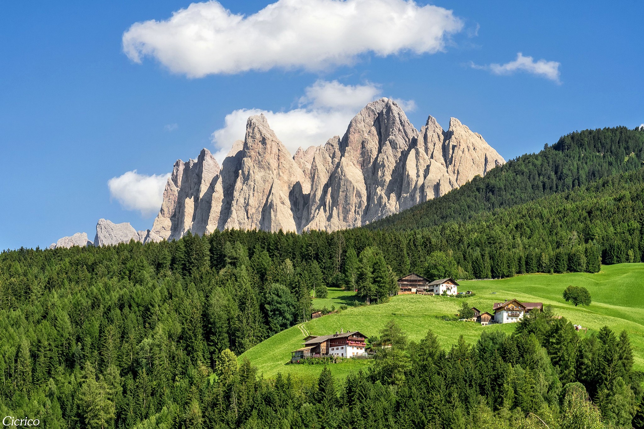 Mountain peaks above forests and houses in San Pietro, Italy HD Wallpaper