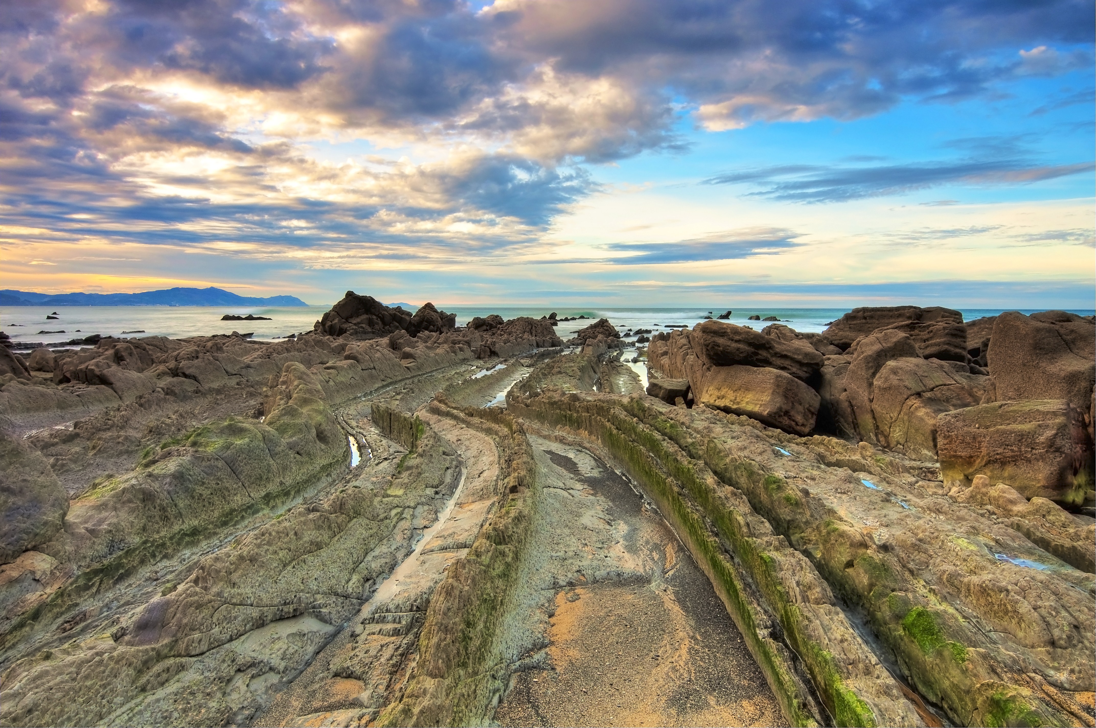 Rocky Coastline Under Dramatic Clouds HD Wallpaper