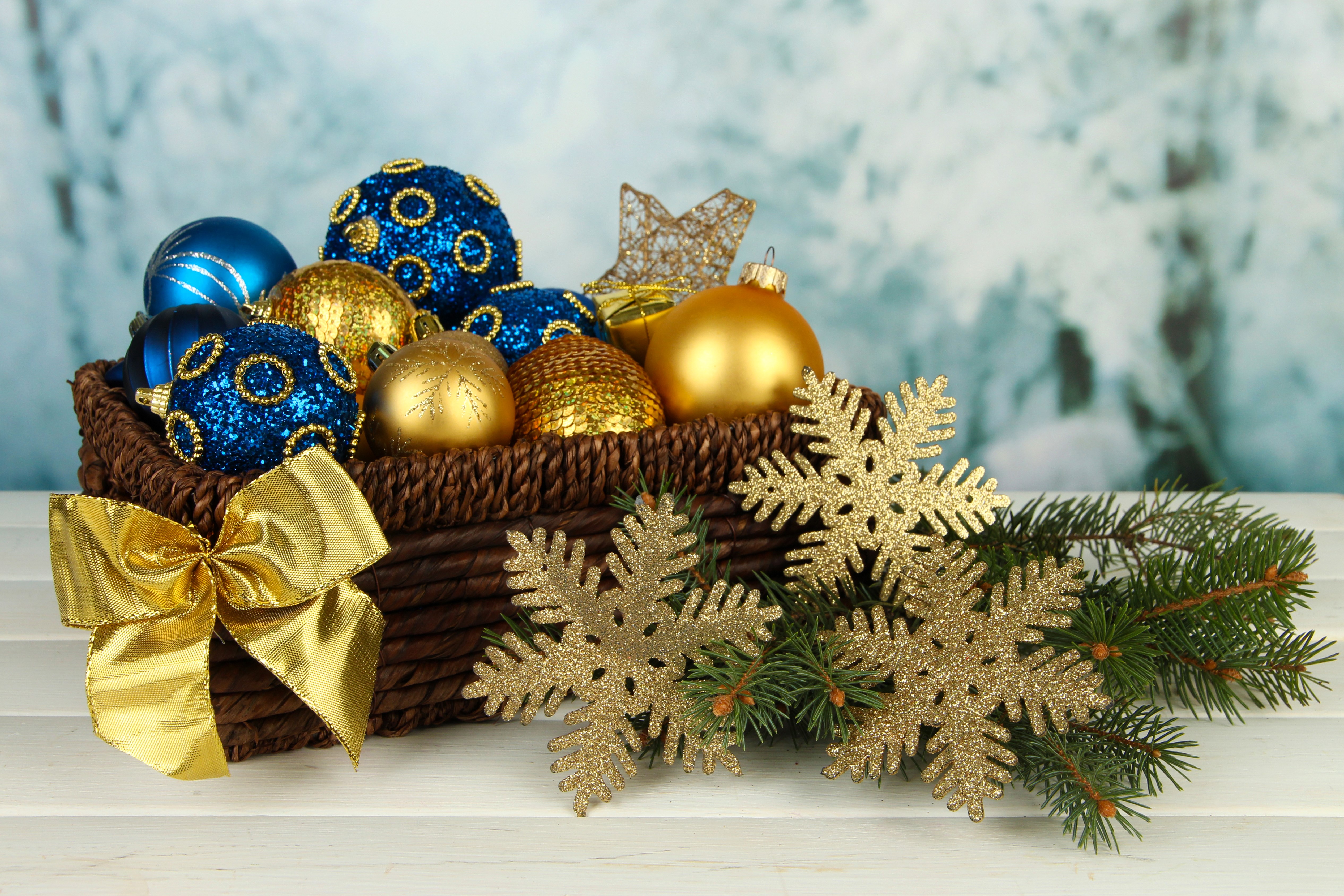Christmas ornaments in a wicker basket with pine branches and snowflakes HD Wallpaper