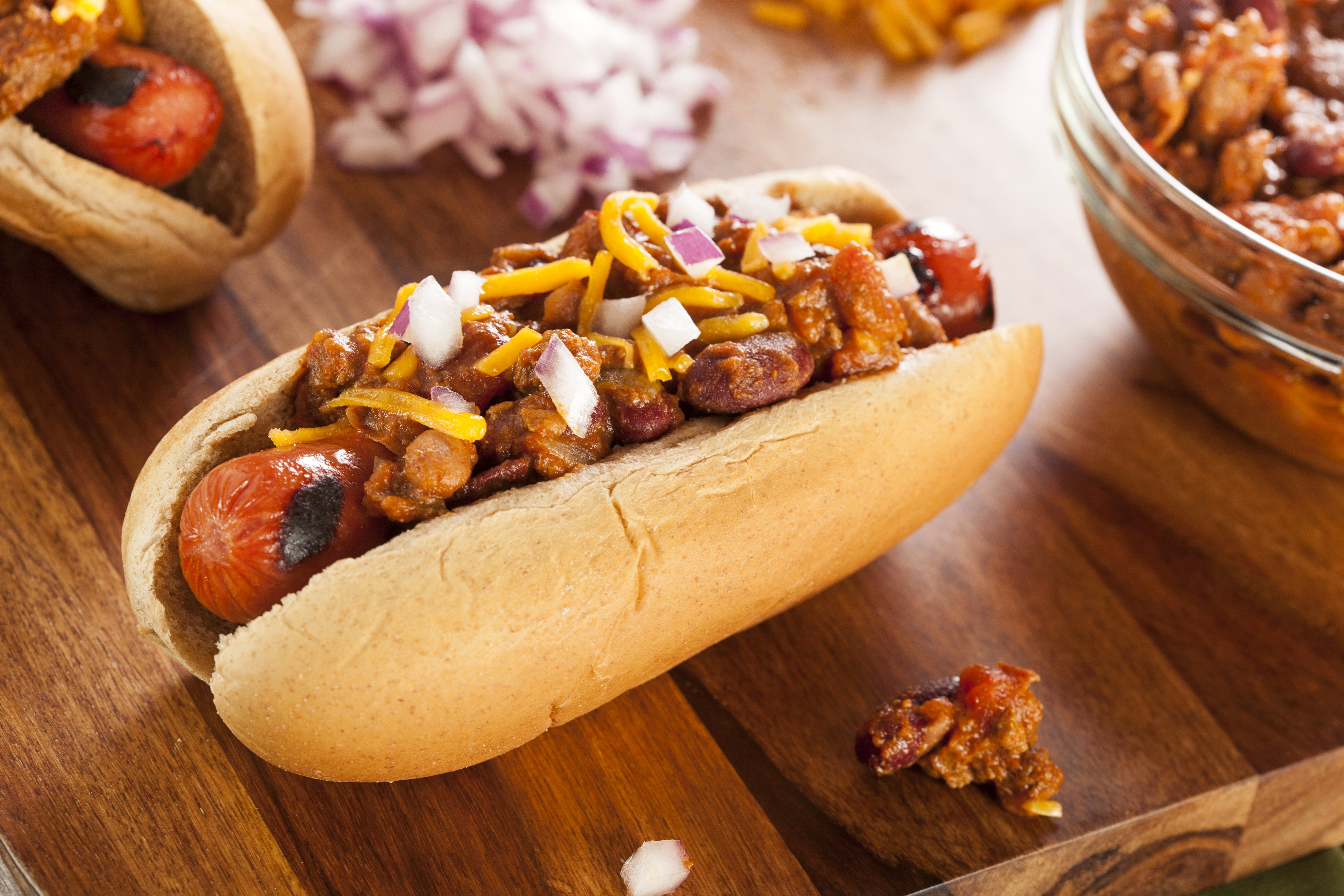 Hot dog with chili, cheese, and onions HD Wallpaper