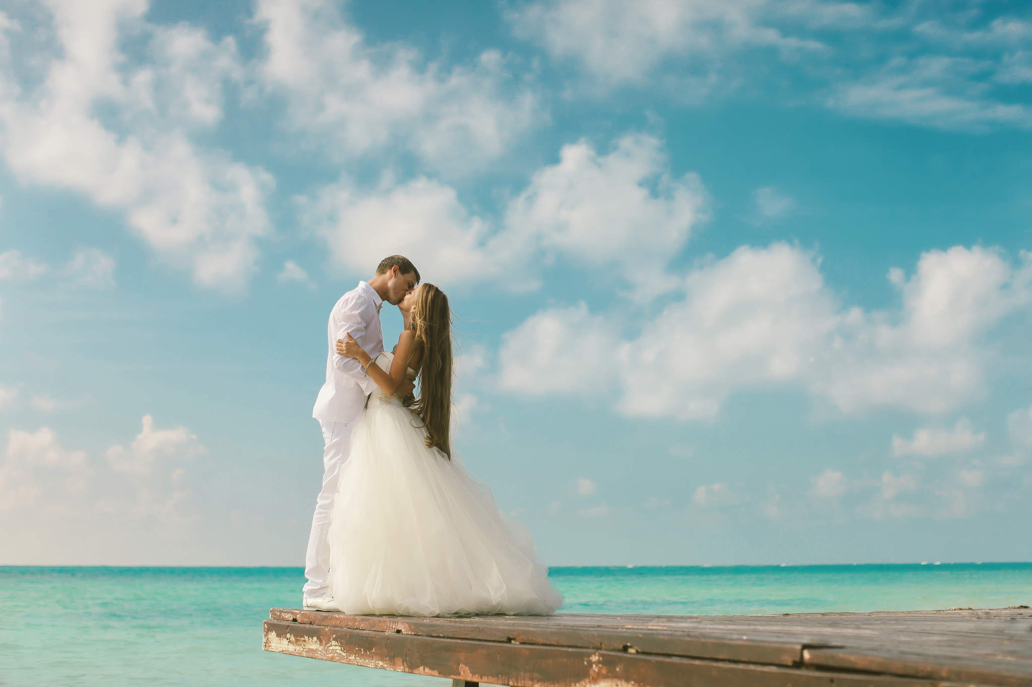 Bride and Groom kissing on a wooden pier HD Wallpaper