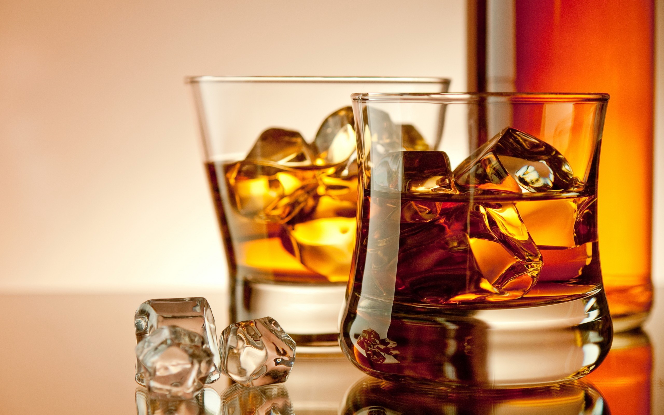 Whiskey glasses with ice and bottle HD Wallpaper