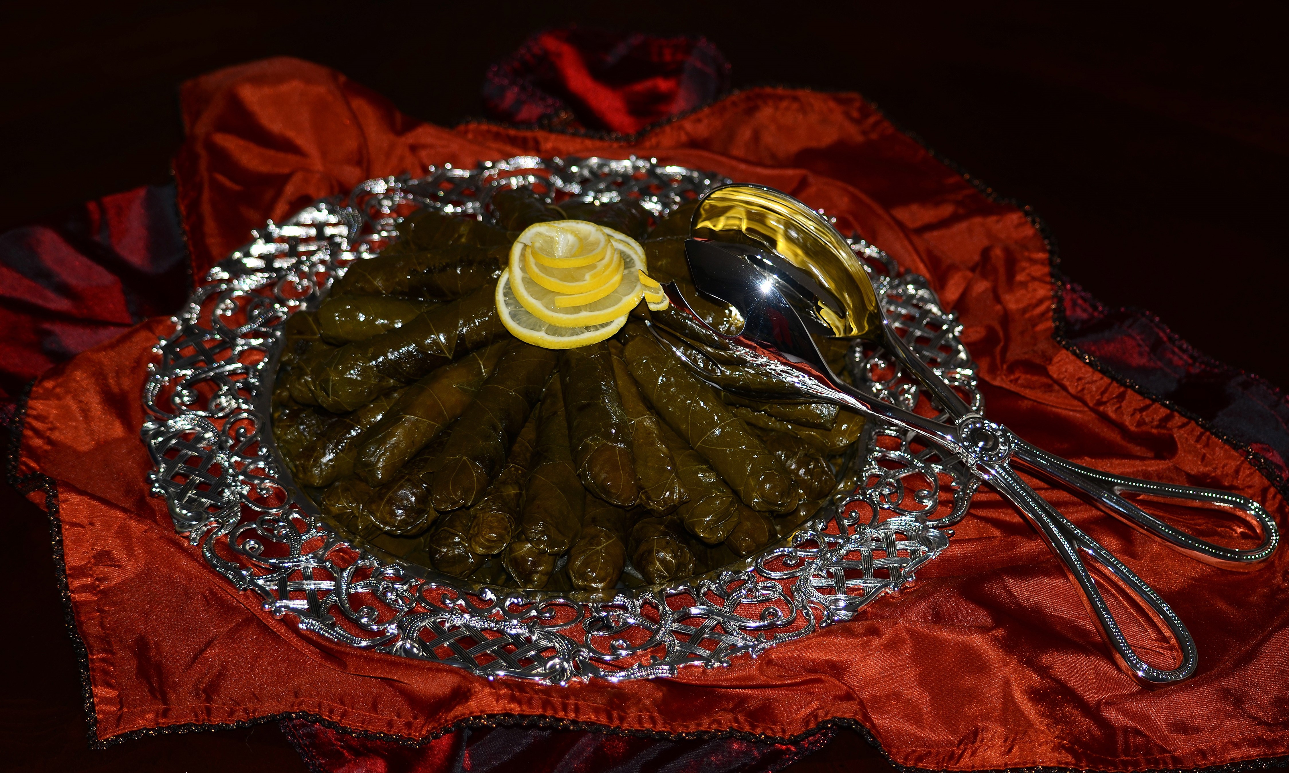 Dolmades with lemon slices and serving tongs HD Wallpaper