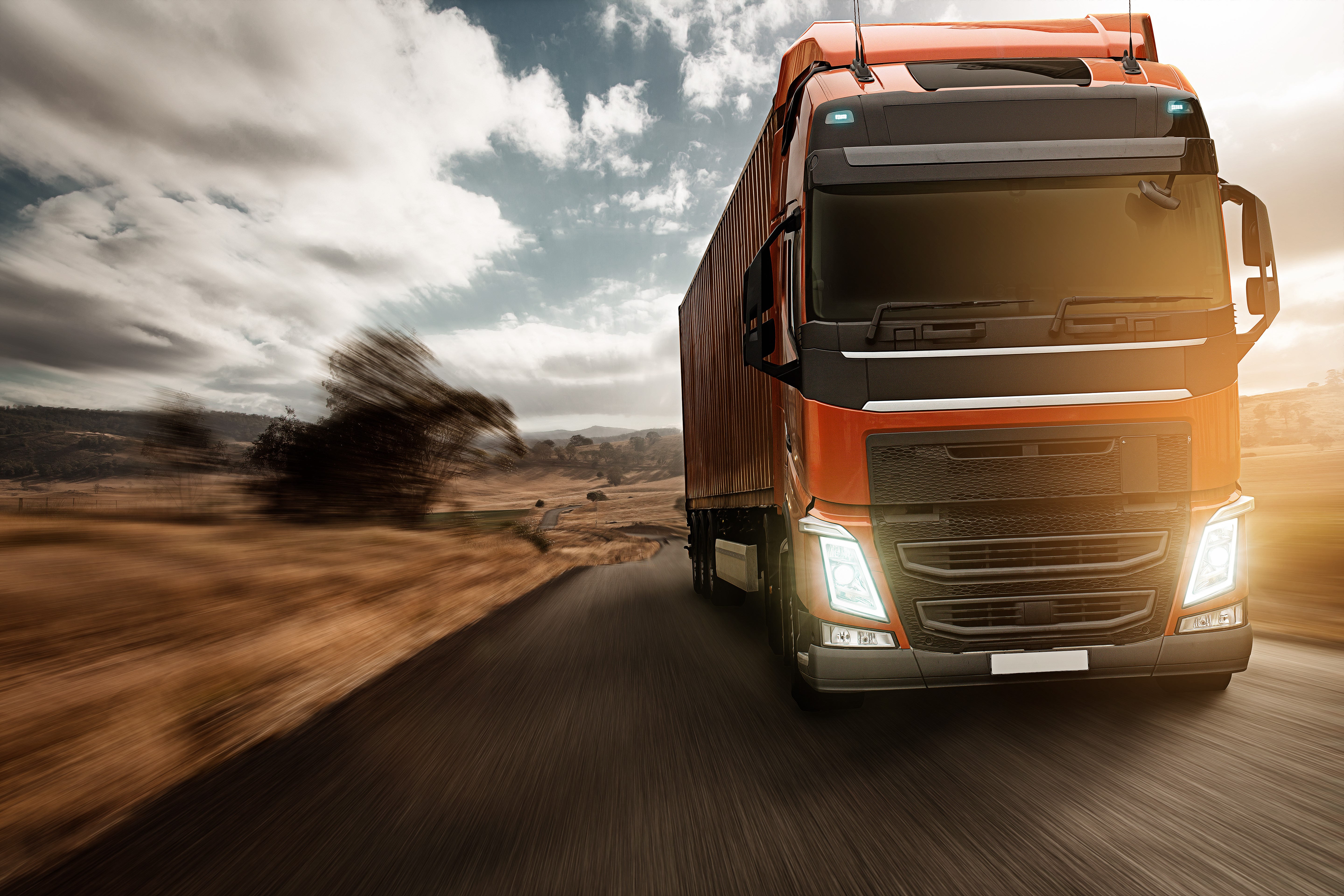 Orange truck driving on a road HD Wallpaper