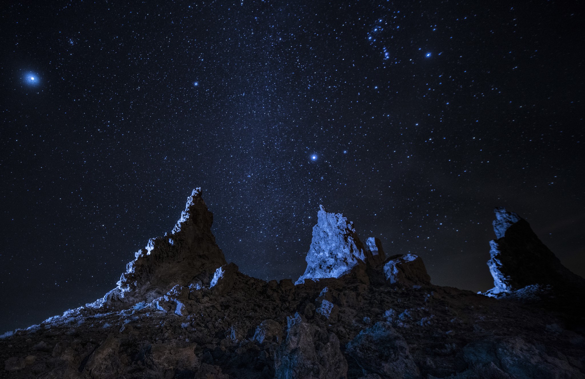 Rocky peaks under a starry night sky HD Wallpaper
