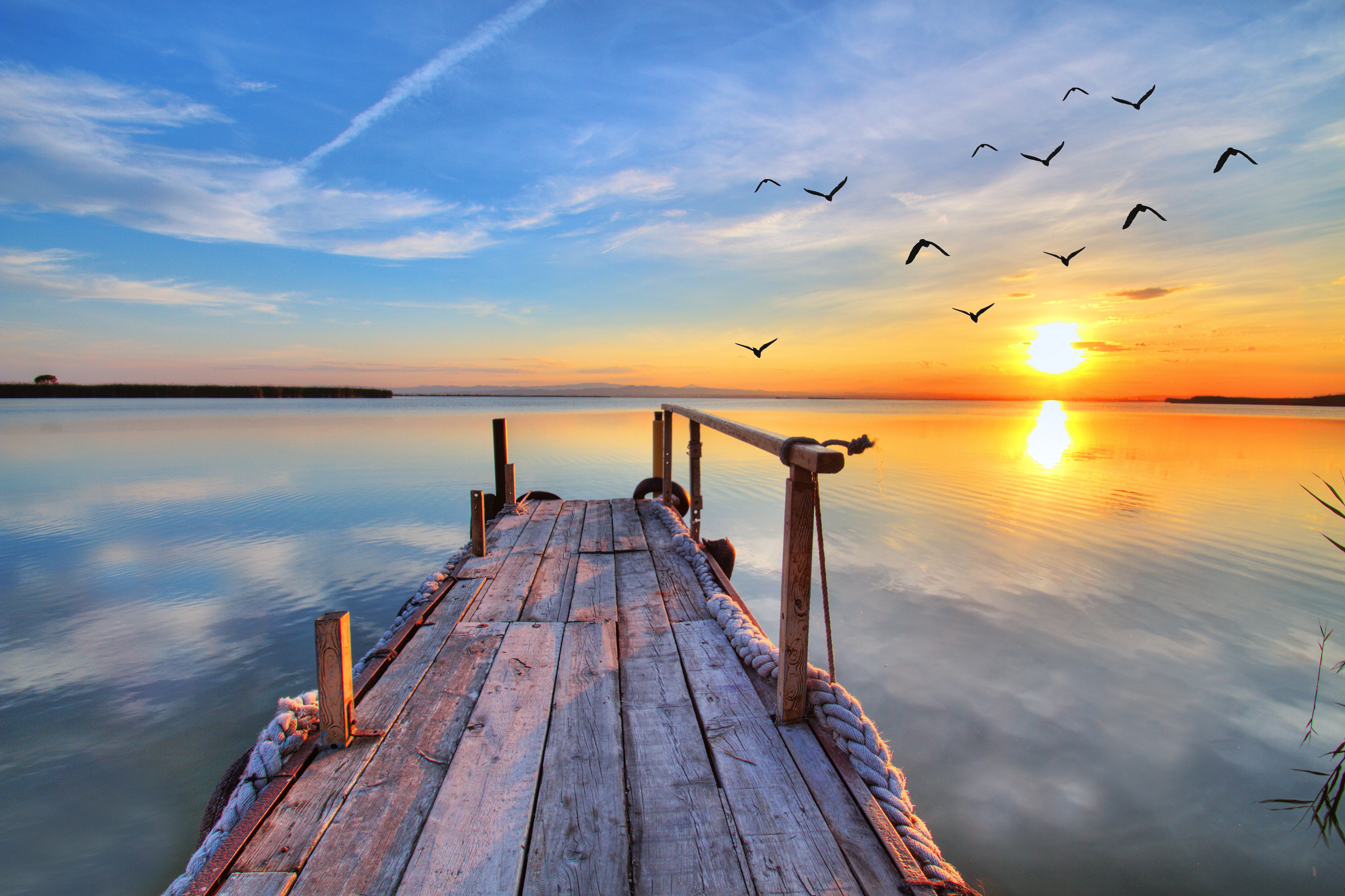 Wooden pier on a lake at sunset with birds flying HD Wallpaper