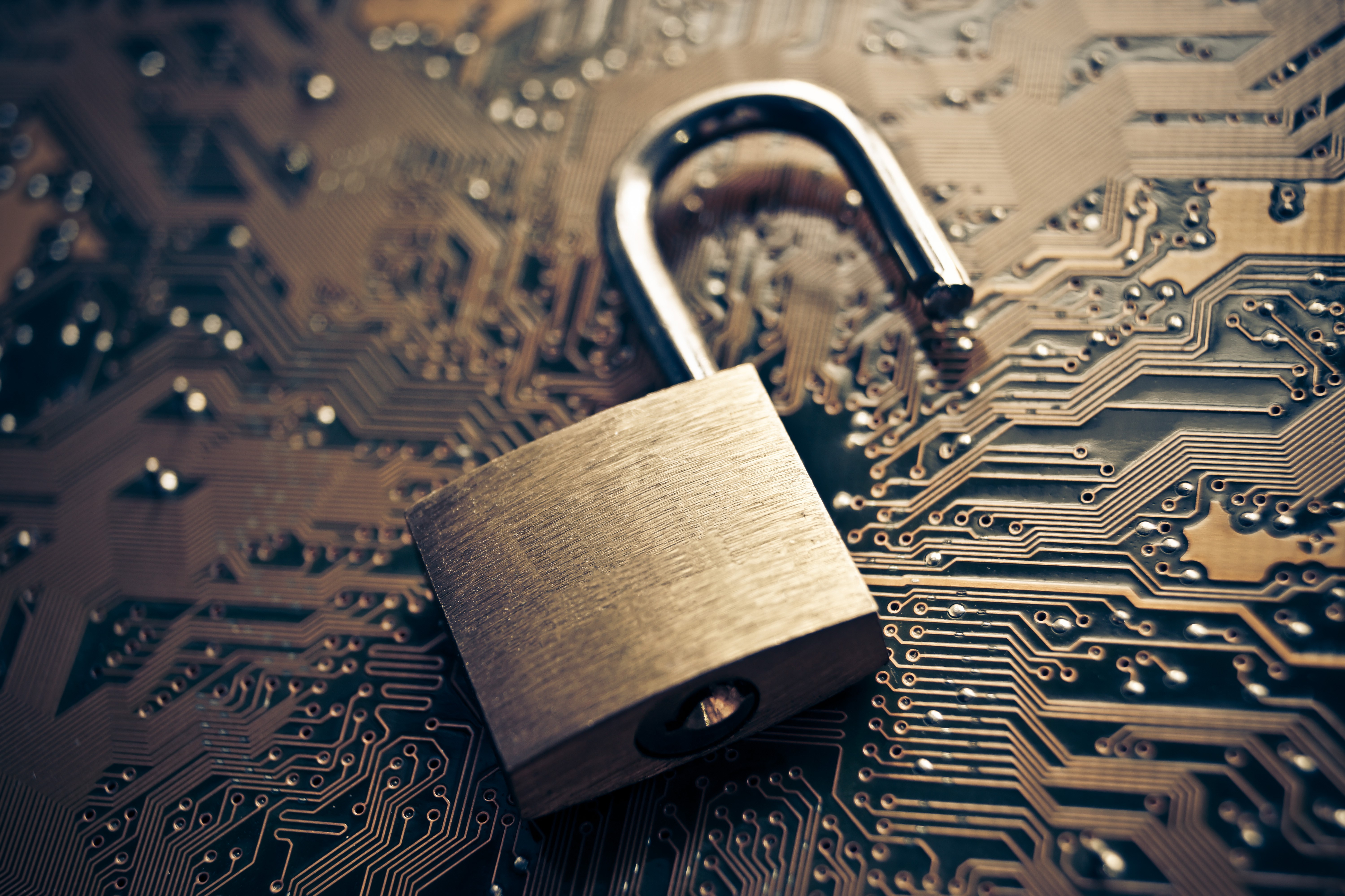 Unlocked padlock on a computer circuit board HD Wallpaper