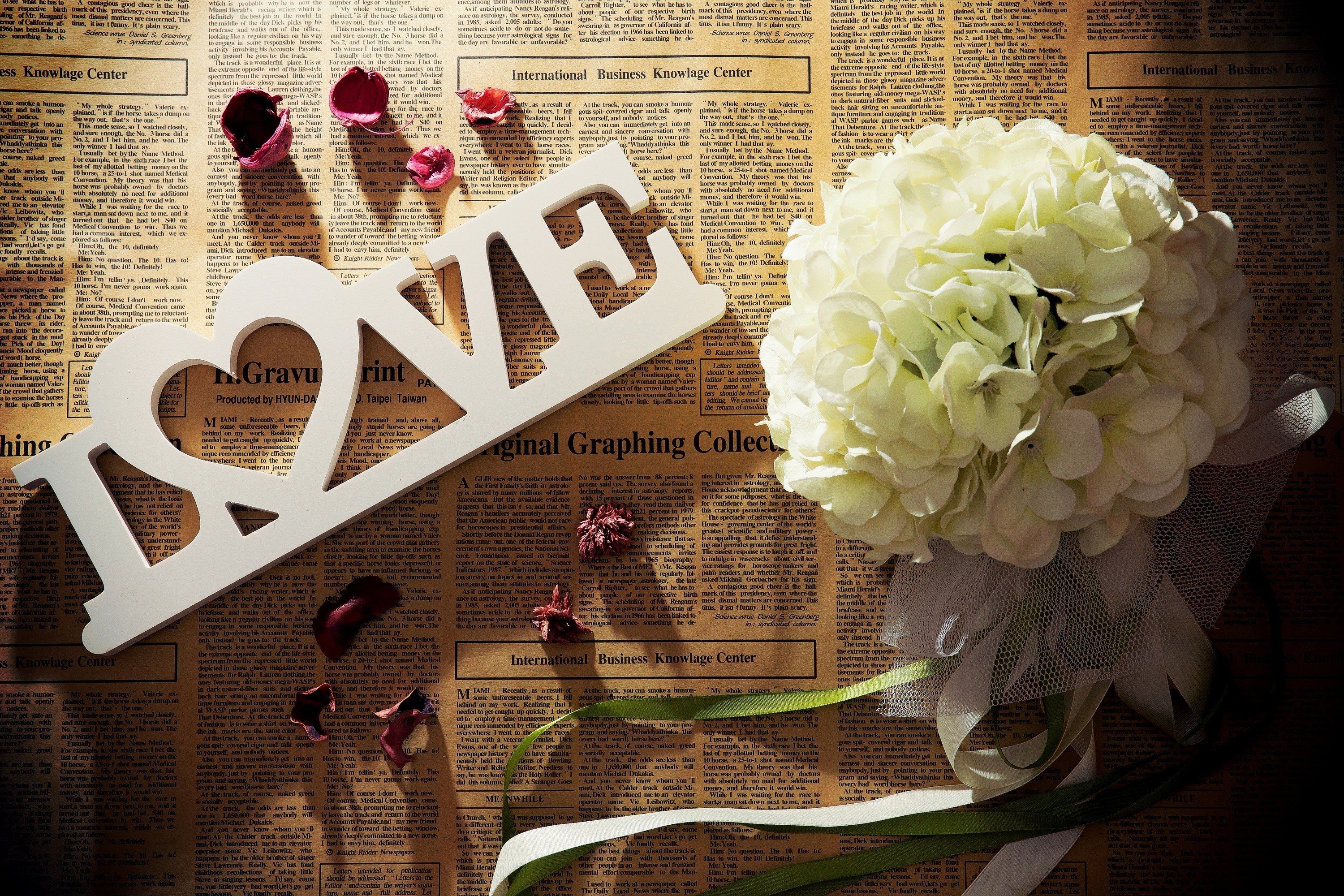 White LOVE sign and bouquet on newspaper HD Wallpaper