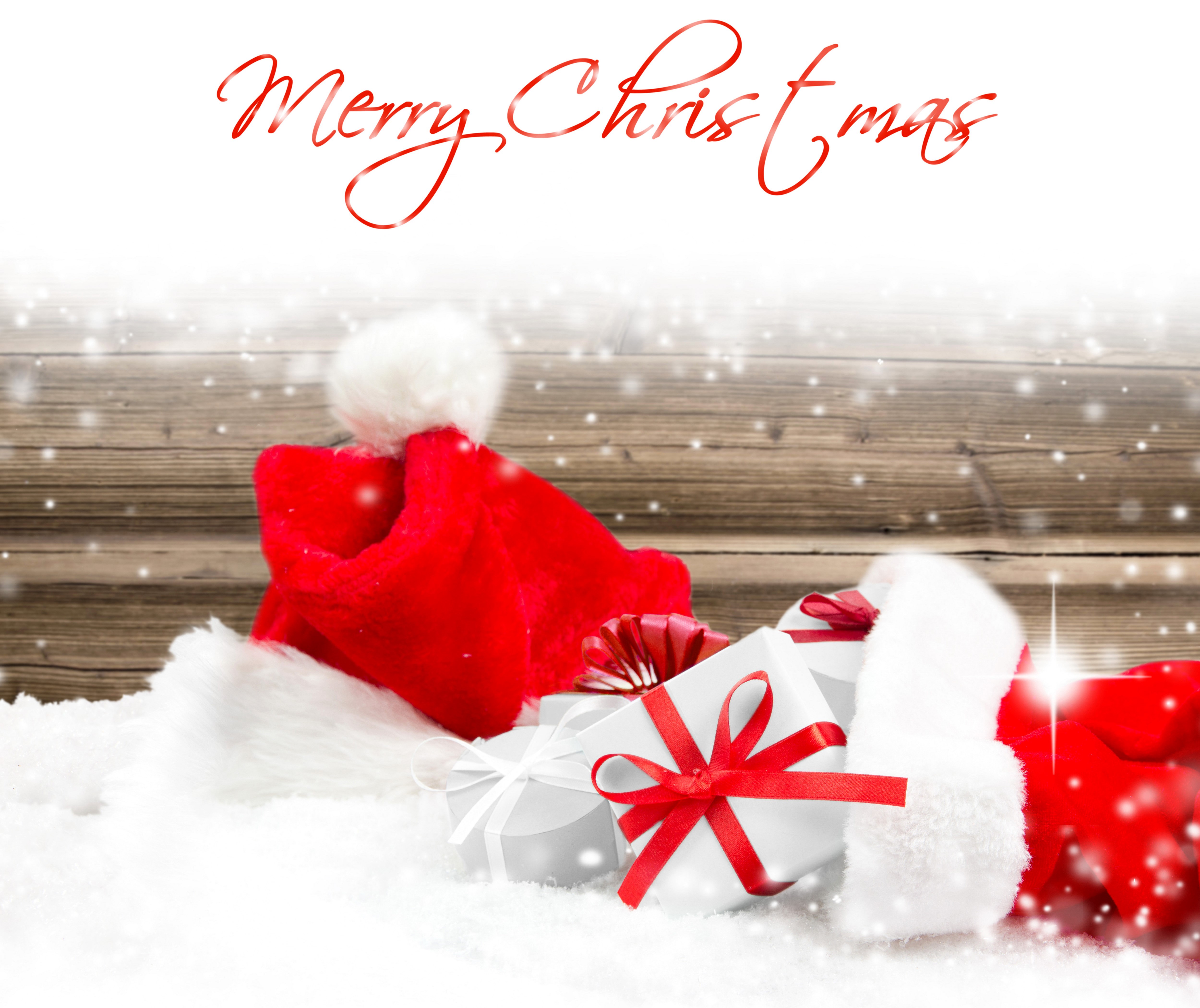 Christmas gifts and Santa hat in snow HD Wallpaper