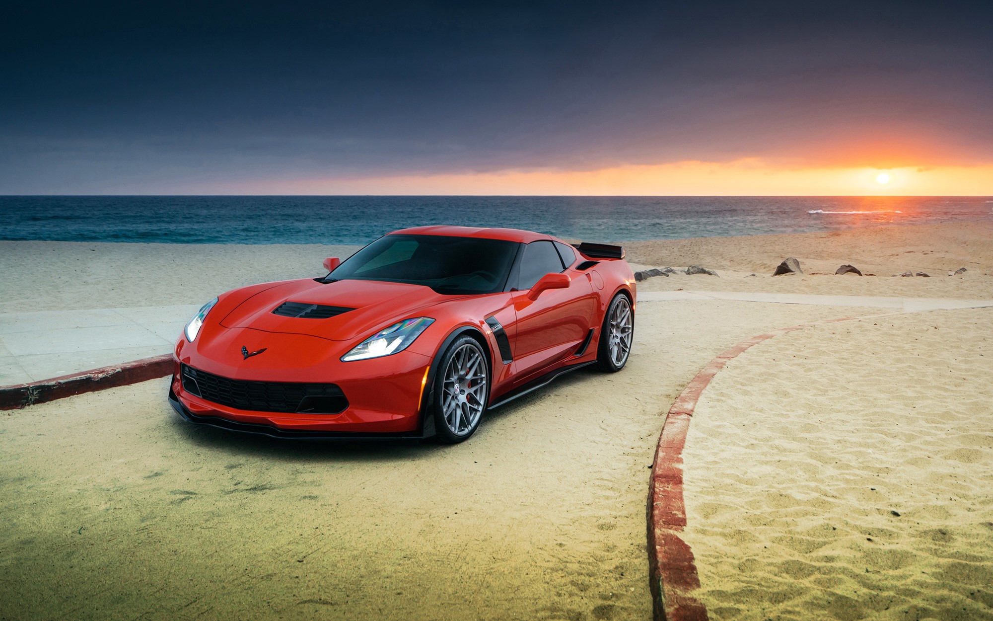 Red Chevrolet Corvette Z06 on a beach at sunset HD Wallpaper