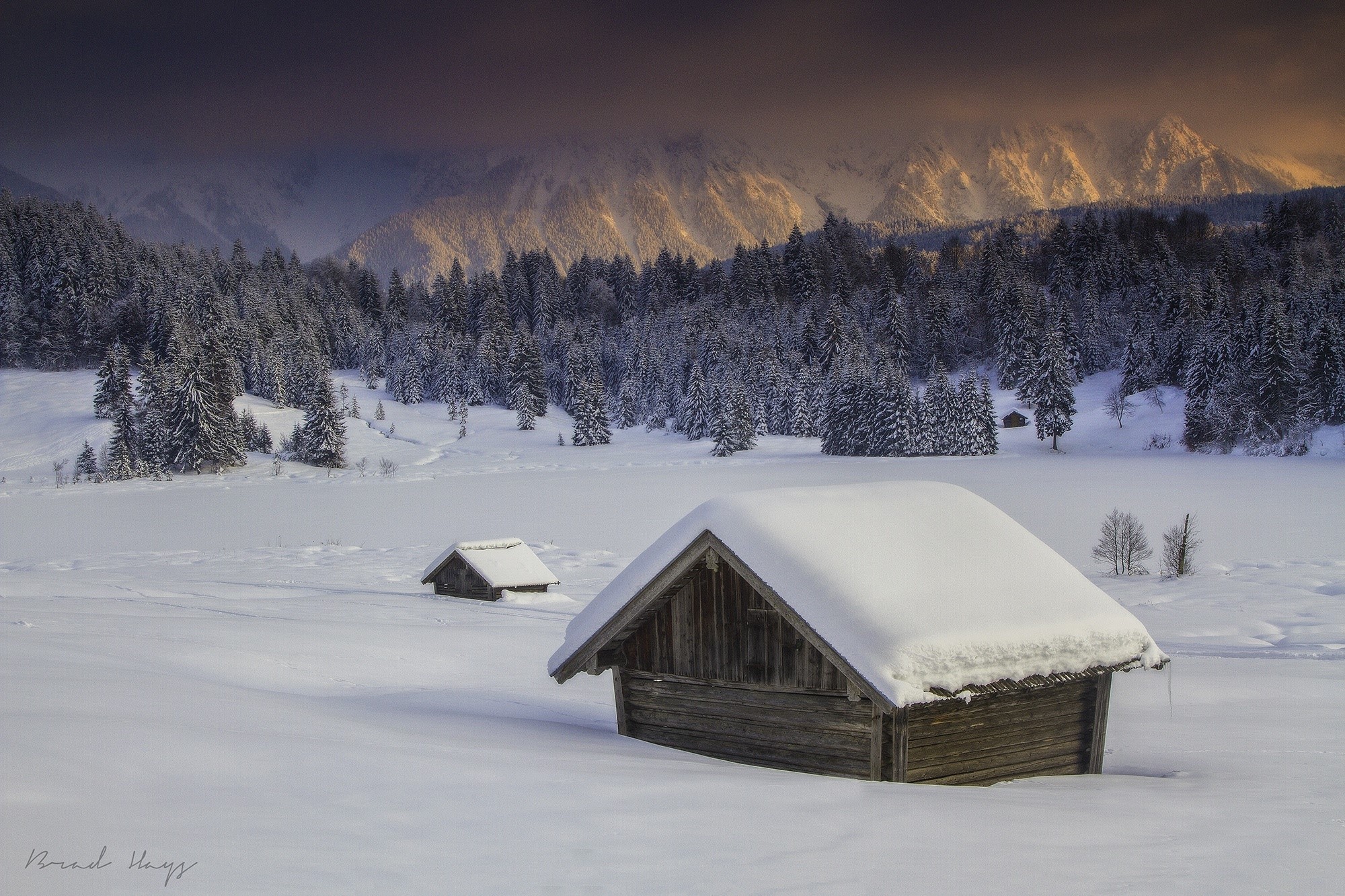 Snow-covered cabins in a winter mountain landscape HD Wallpaper