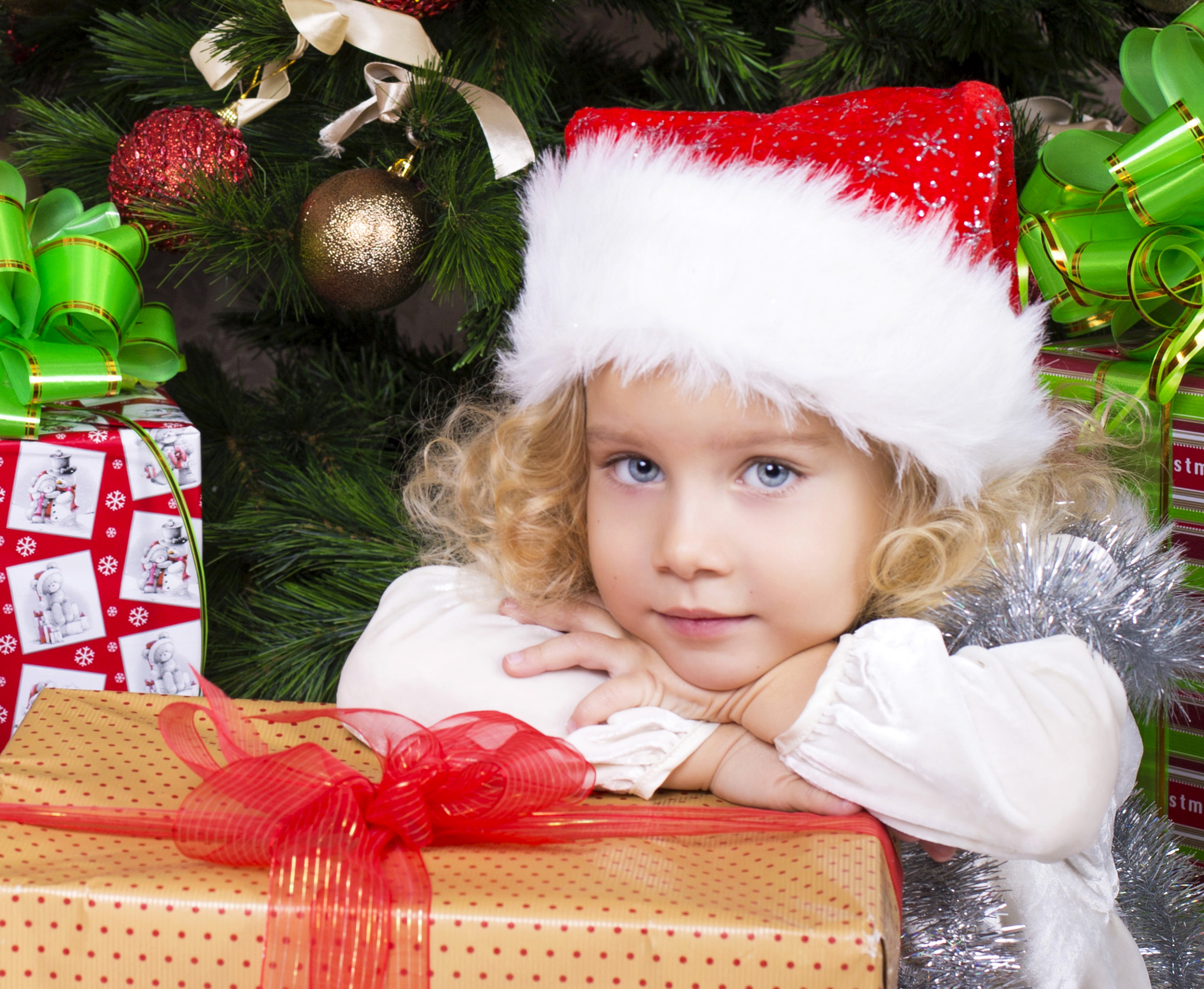 Little girl in Santa hat with Christmas gifts HD Wallpaper