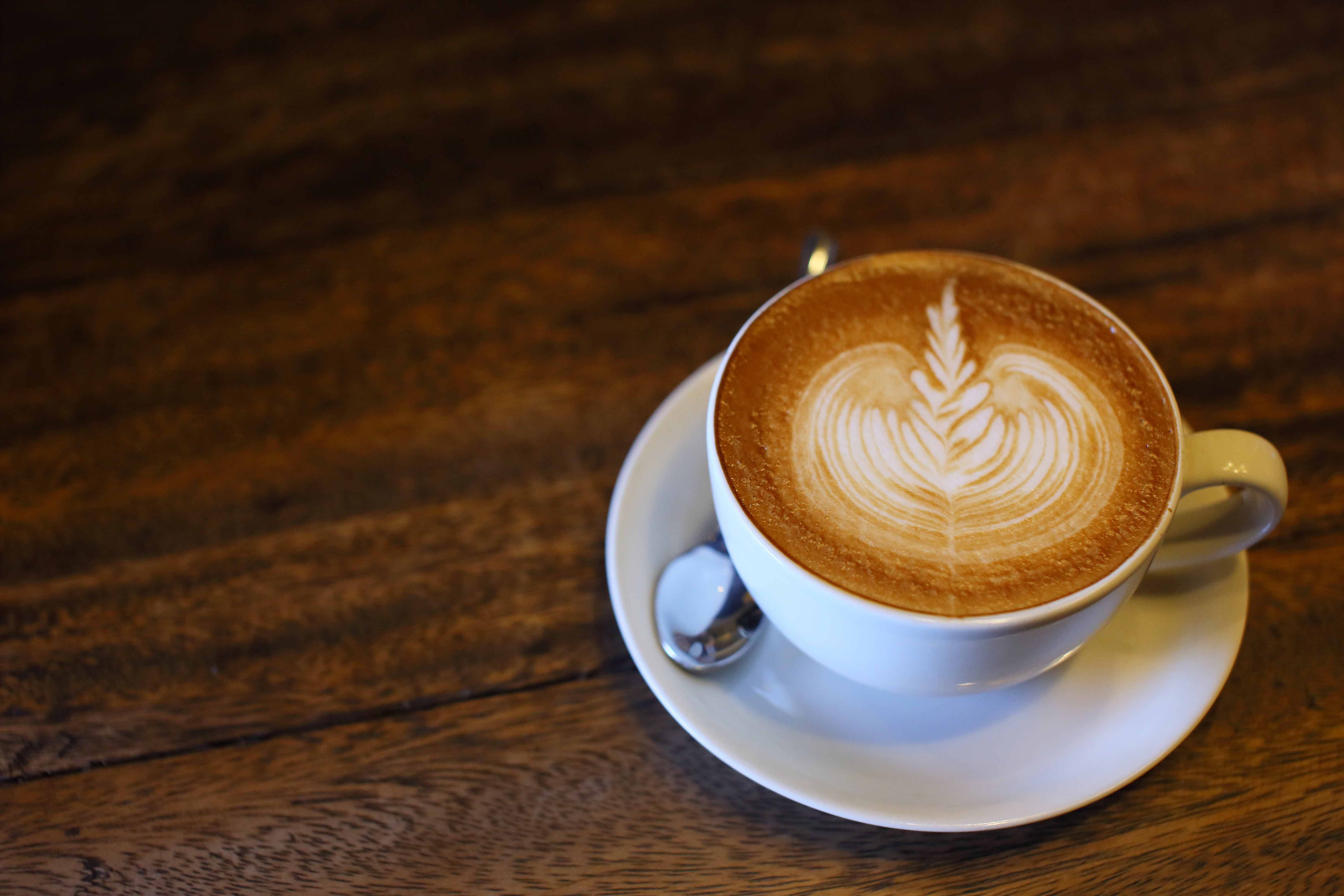 Cappuccino with latte art in a white cup HD Wallpaper