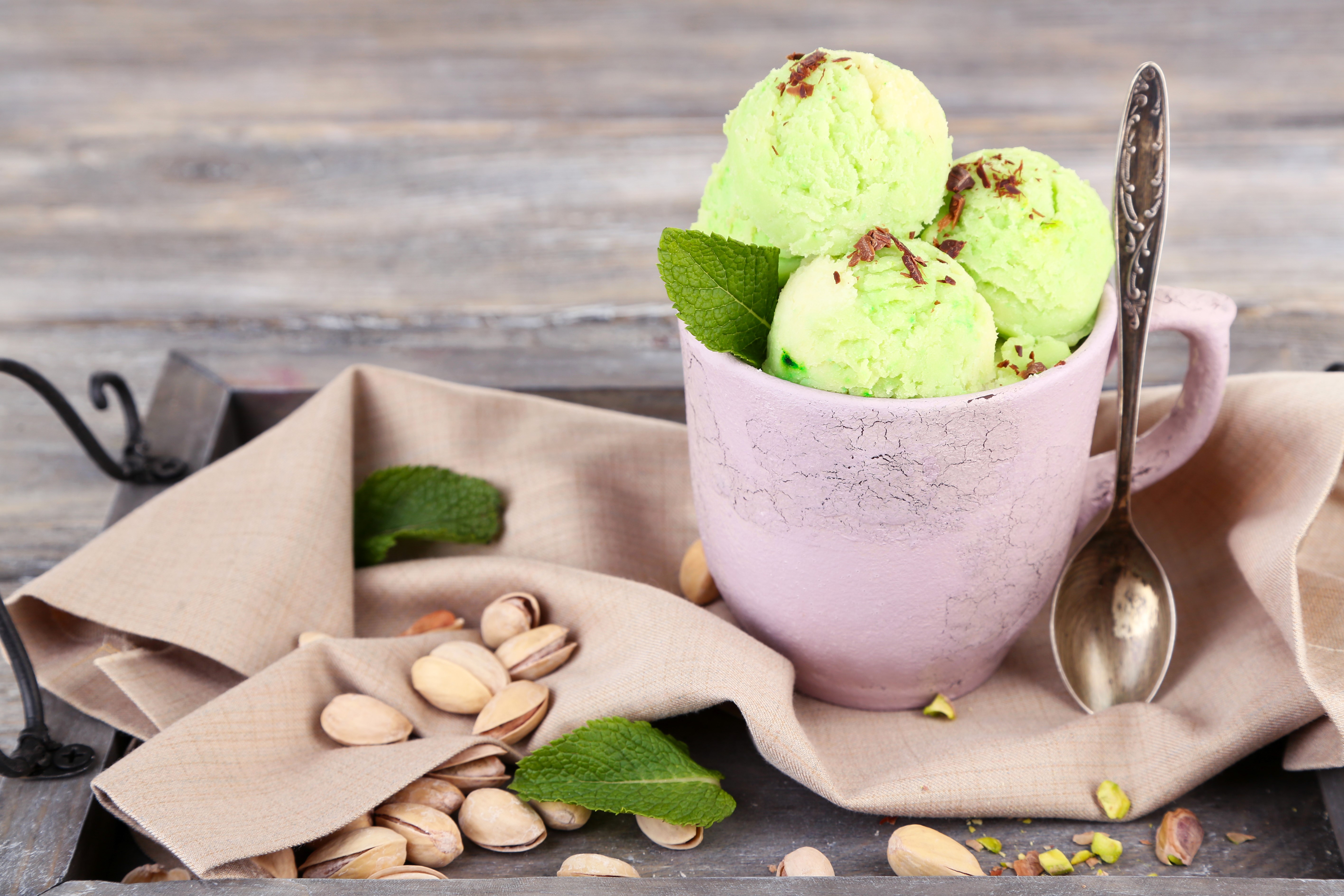 Pistachio ice cream in a cup with pistachios and mint HD Wallpaper