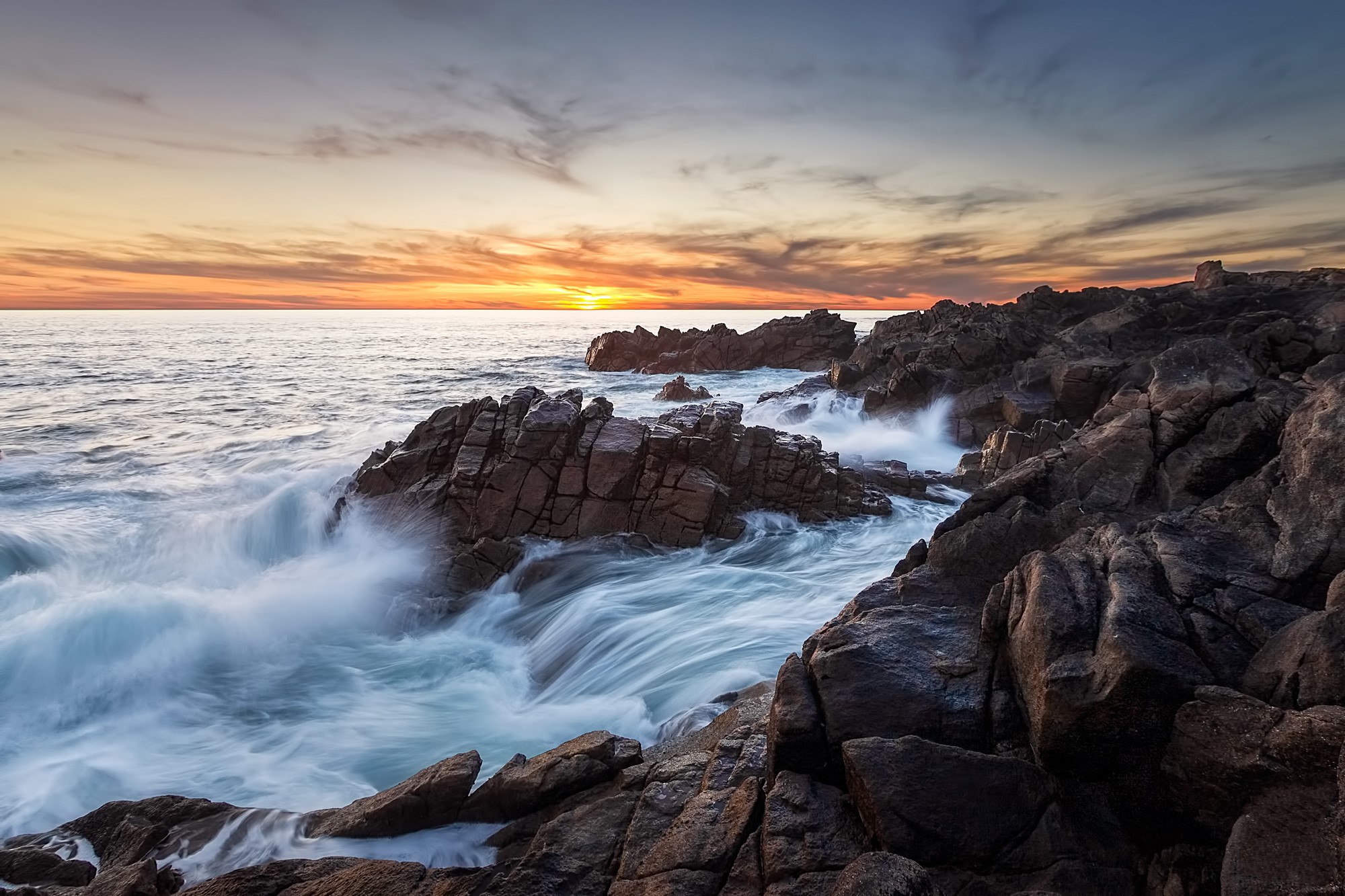 Sunset over rocky coastline with crashing waves HD Wallpaper