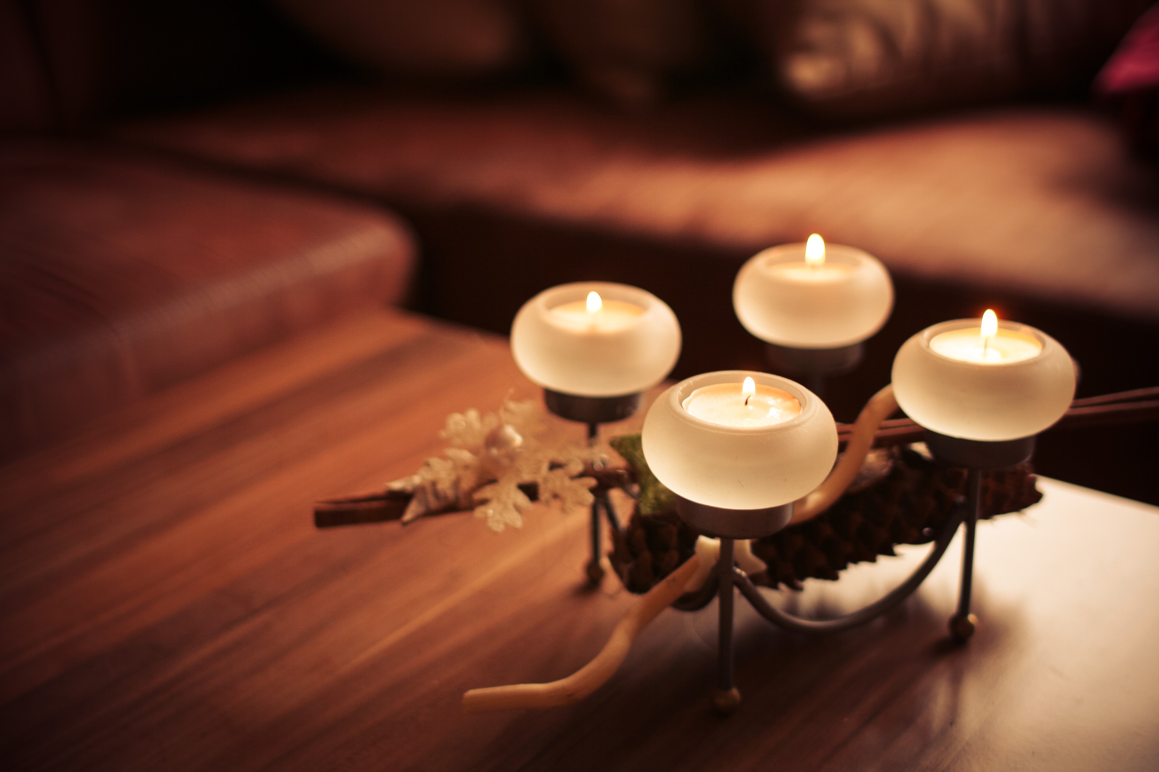 Four lit candles on a wooden table HD Wallpaper