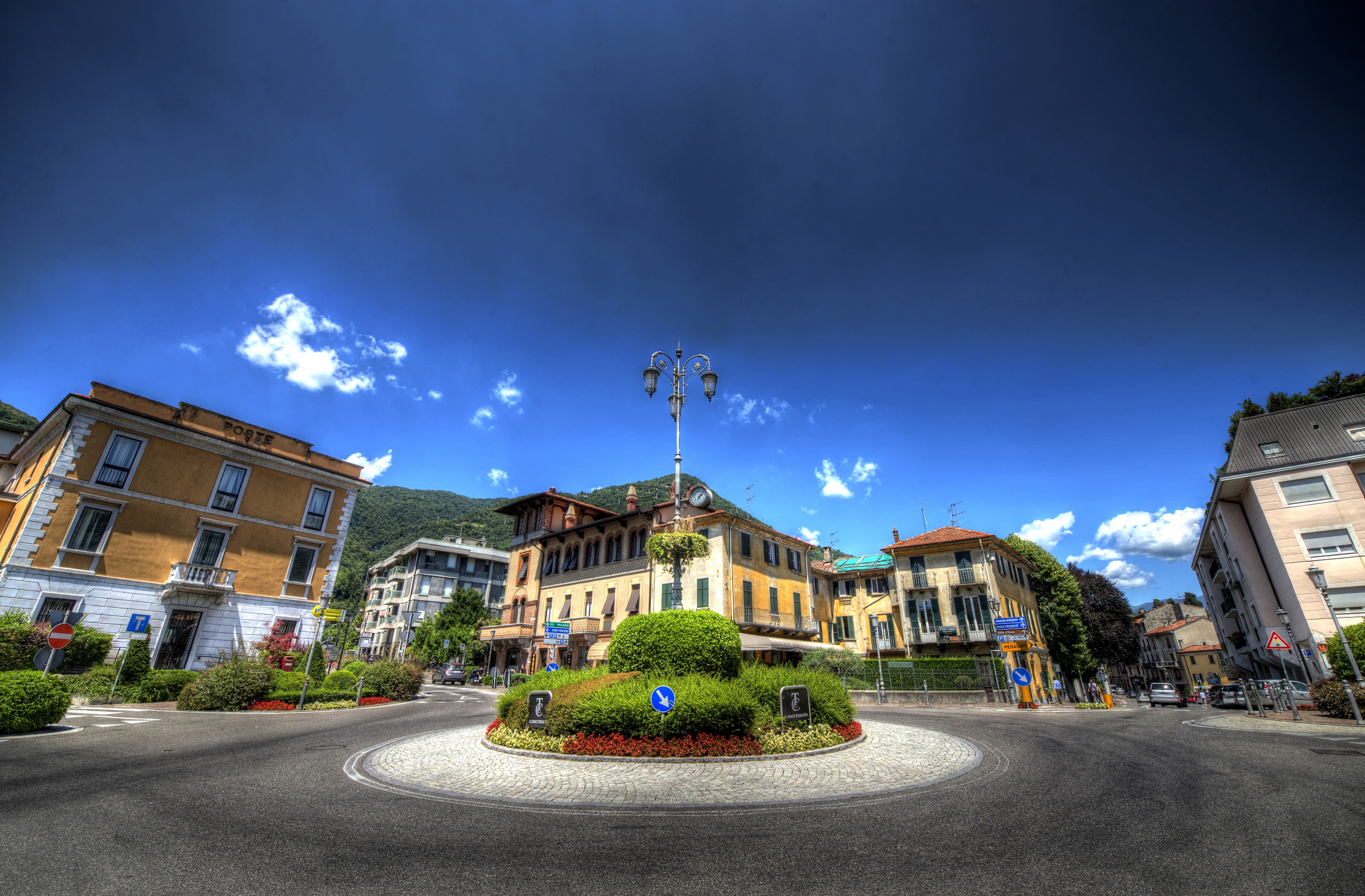 Roundabout in Cernobbio, Italy with buildings and mountains HD Wallpaper