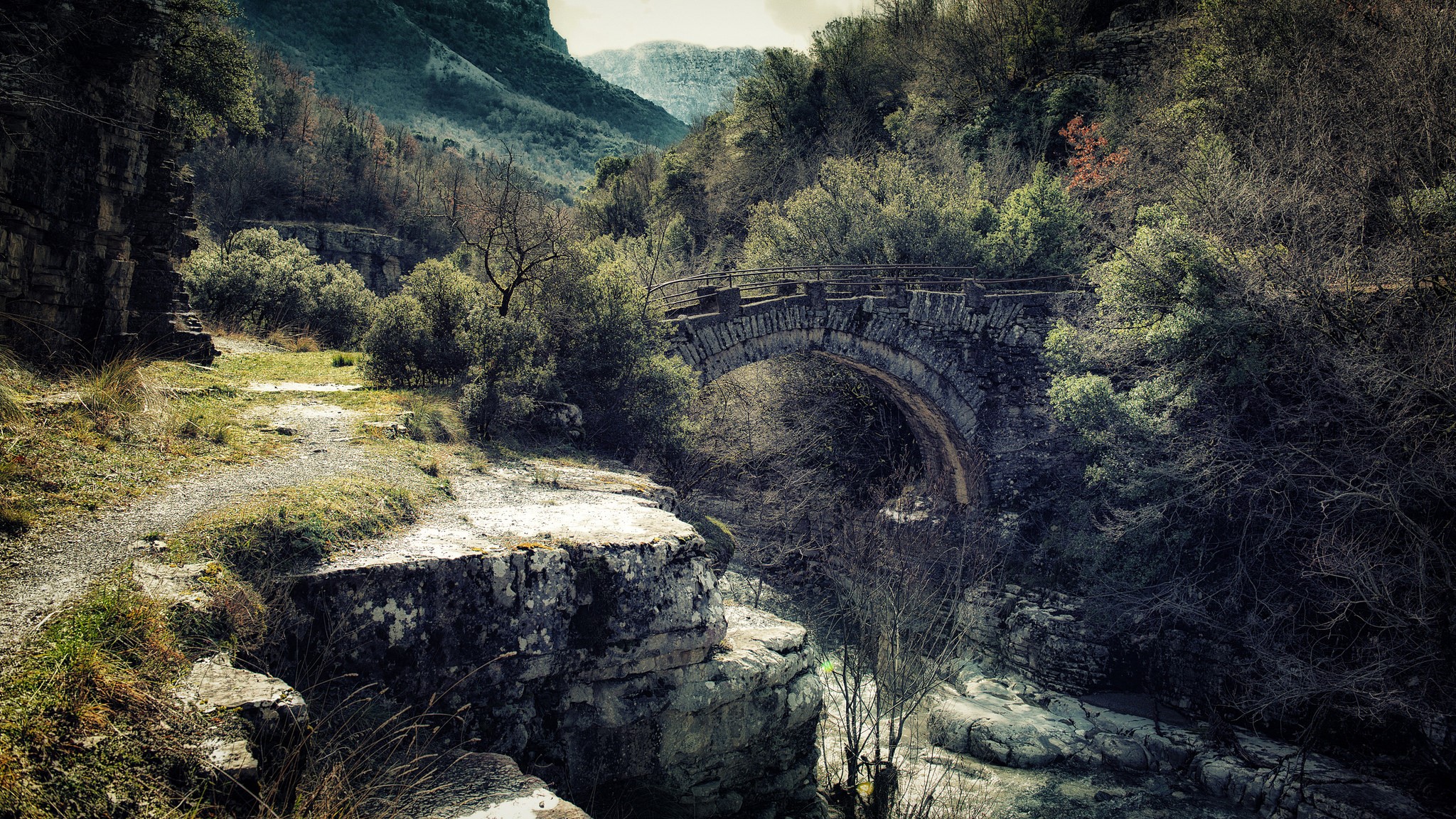 Stone bridge over a river in a wooded mountain landscape HD Wallpaper
