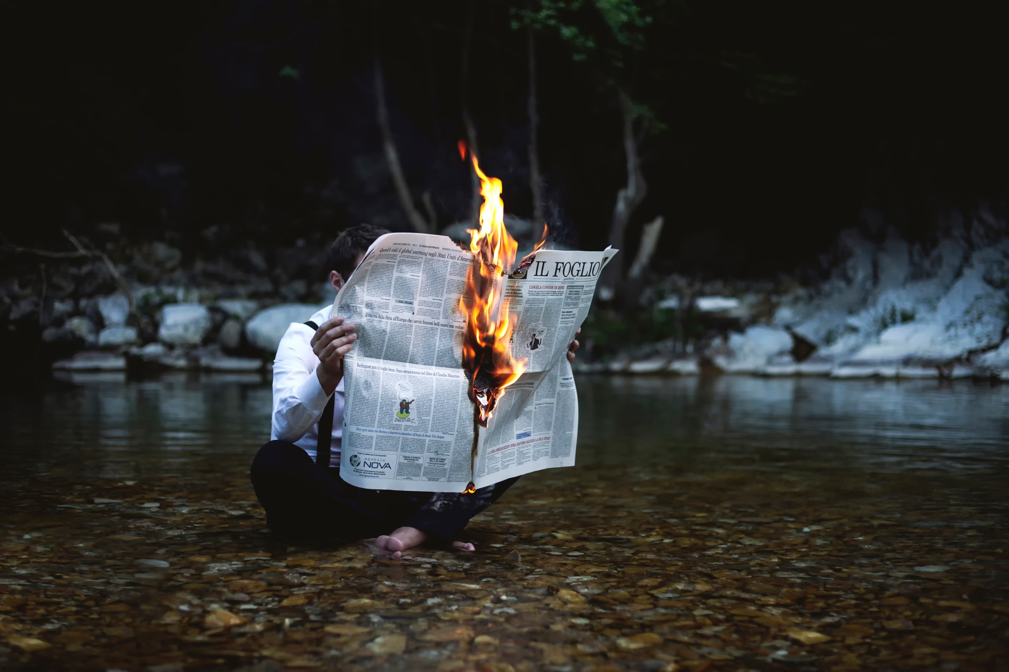 Man reading a burning newspaper in a stream HD Wallpaper