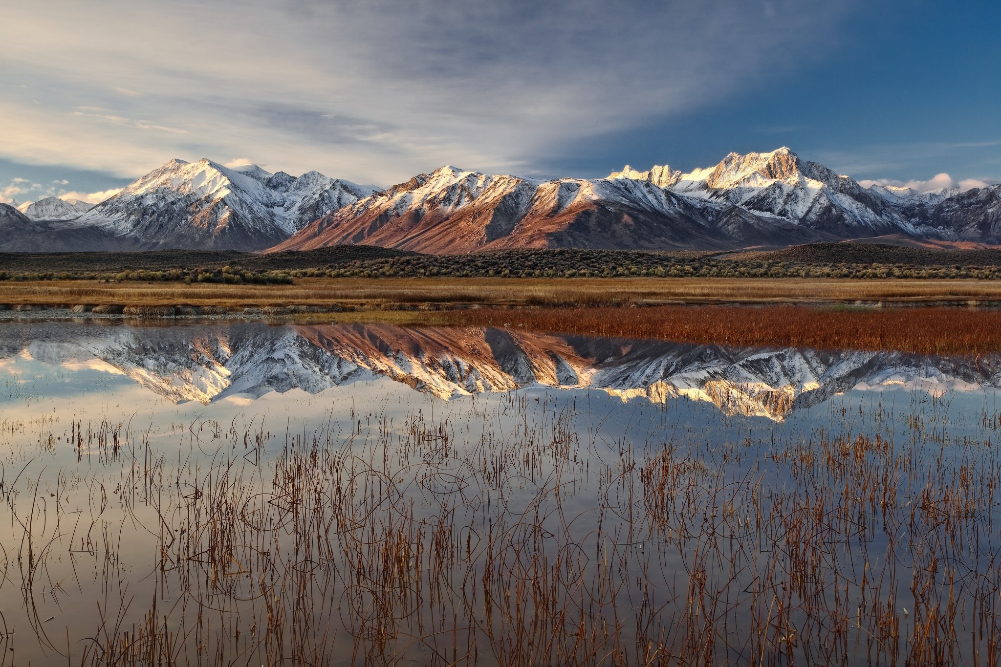 Snow-capped mountains reflected in a calm lake HD Wallpaper