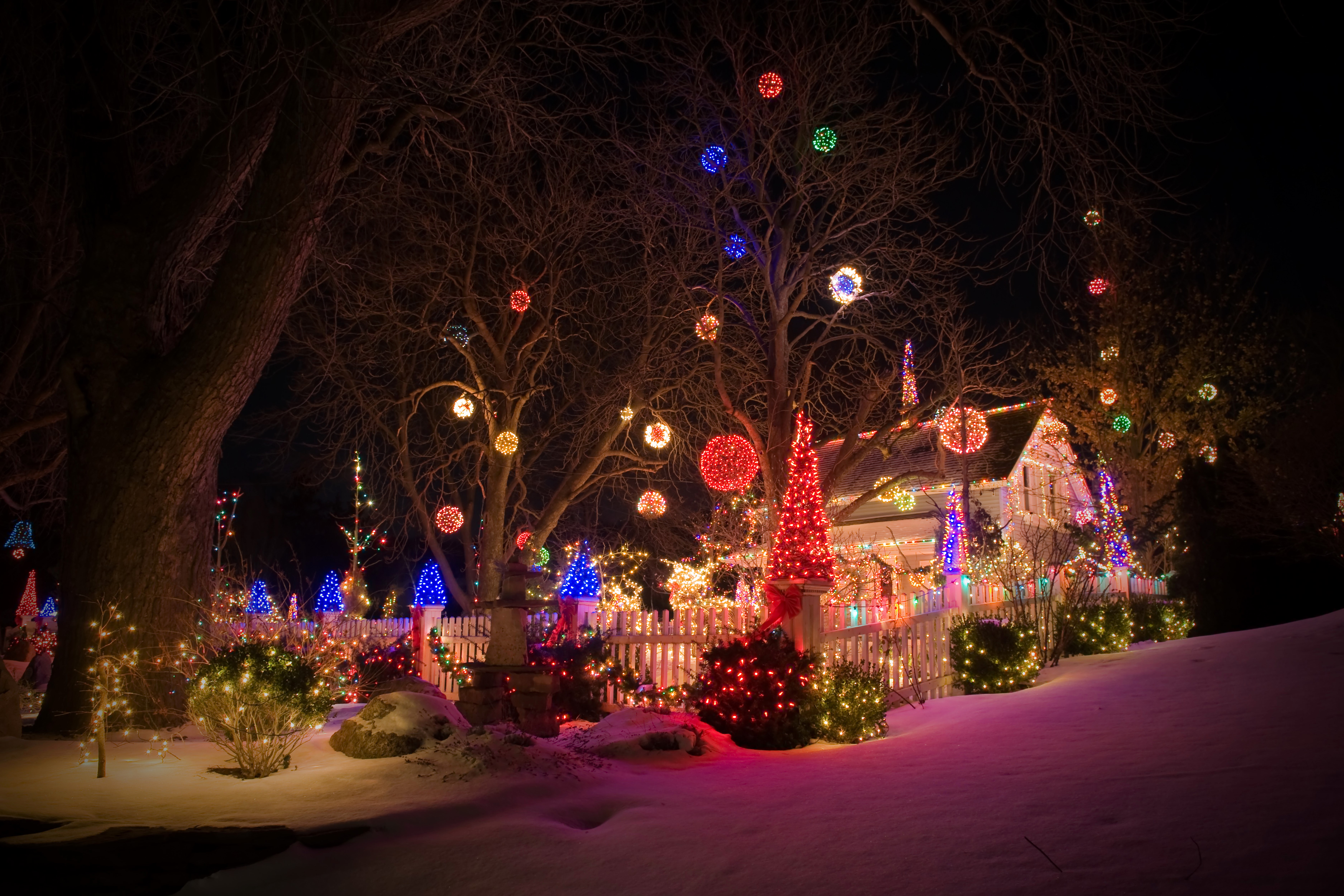 House decorated with Christmas lights in the snow at night HD Wallpaper