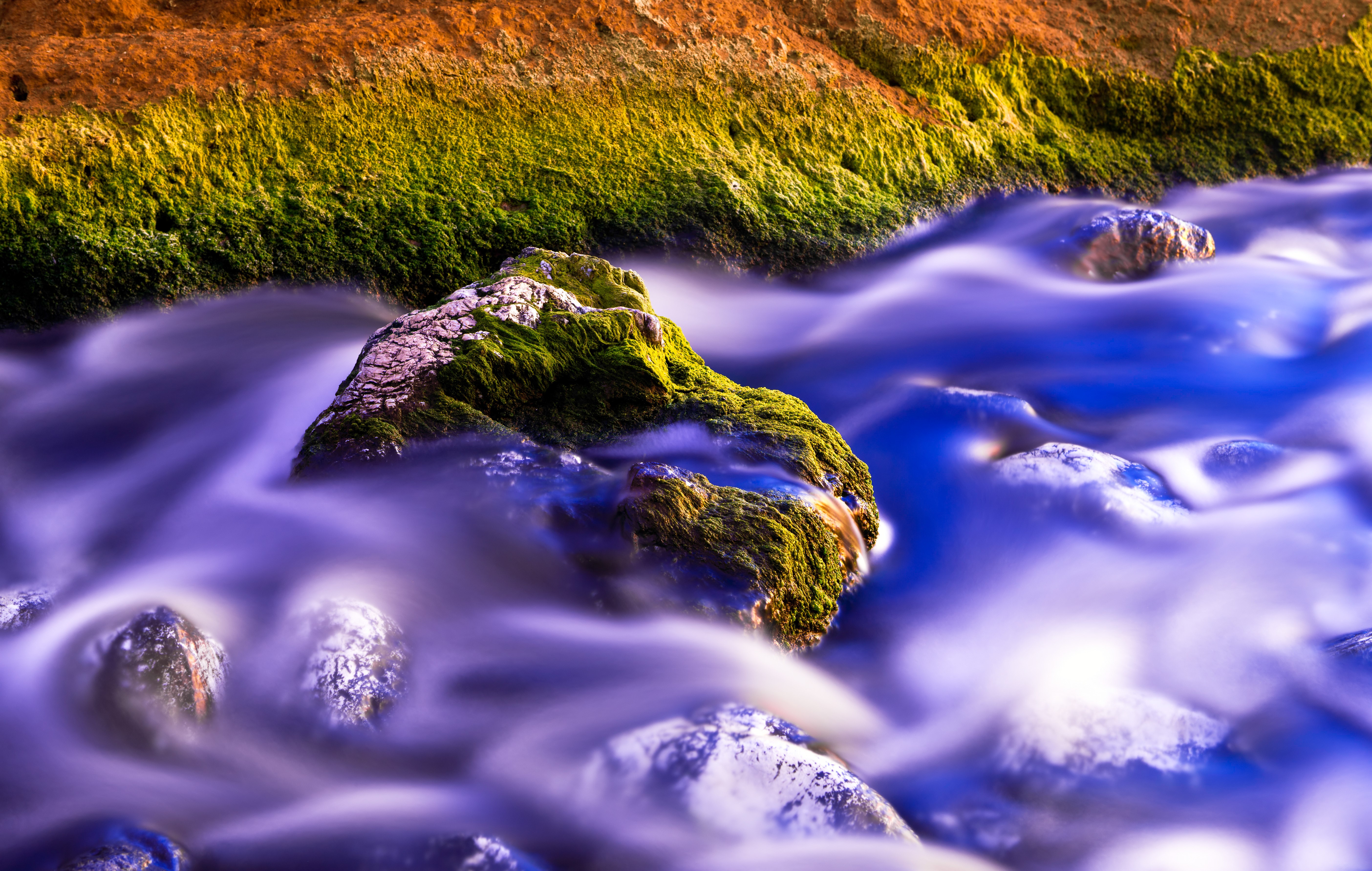 Mossy rocks in a flowing stream HD Wallpaper