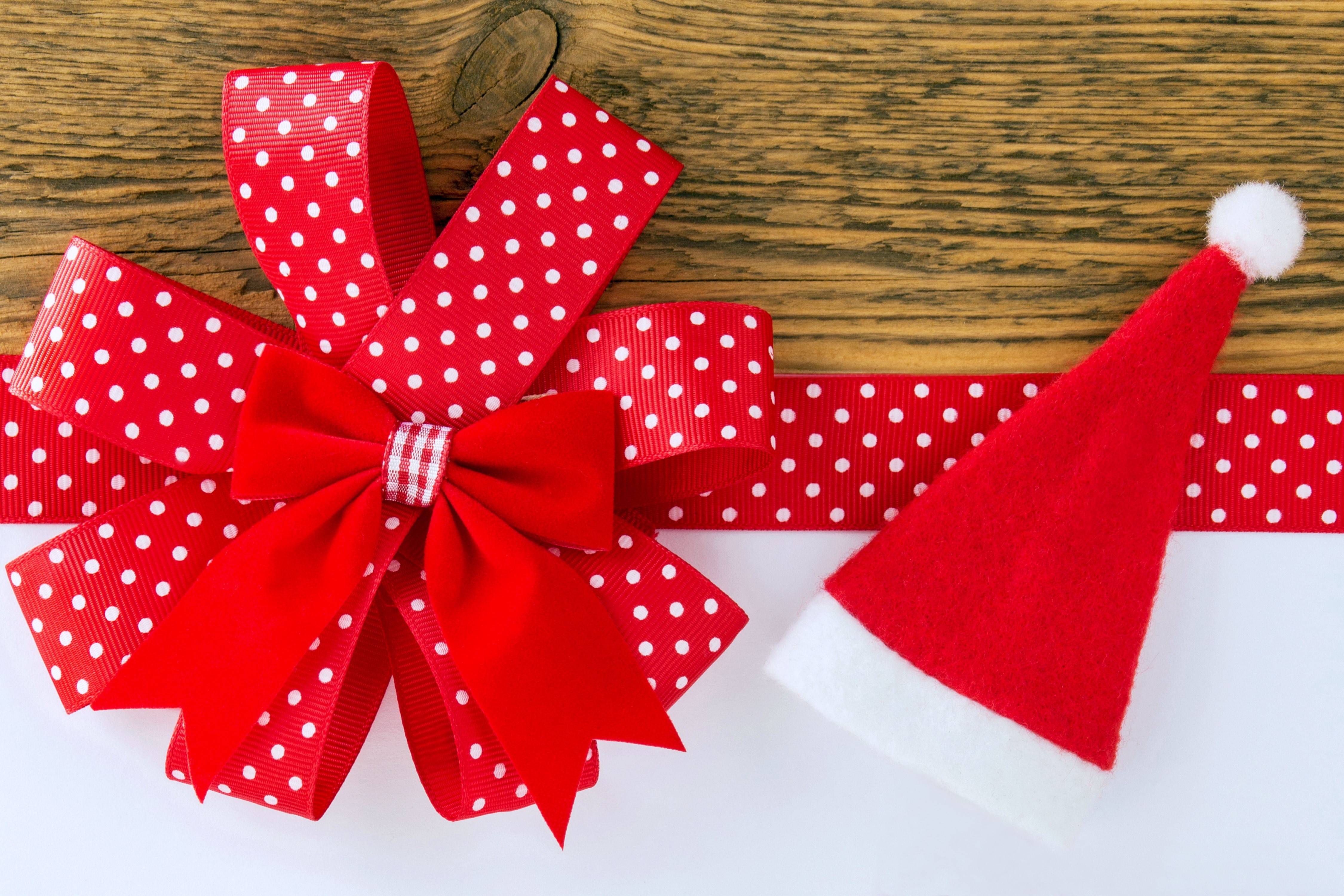 Christmas ribbon and Santa hat on wood HD Wallpaper