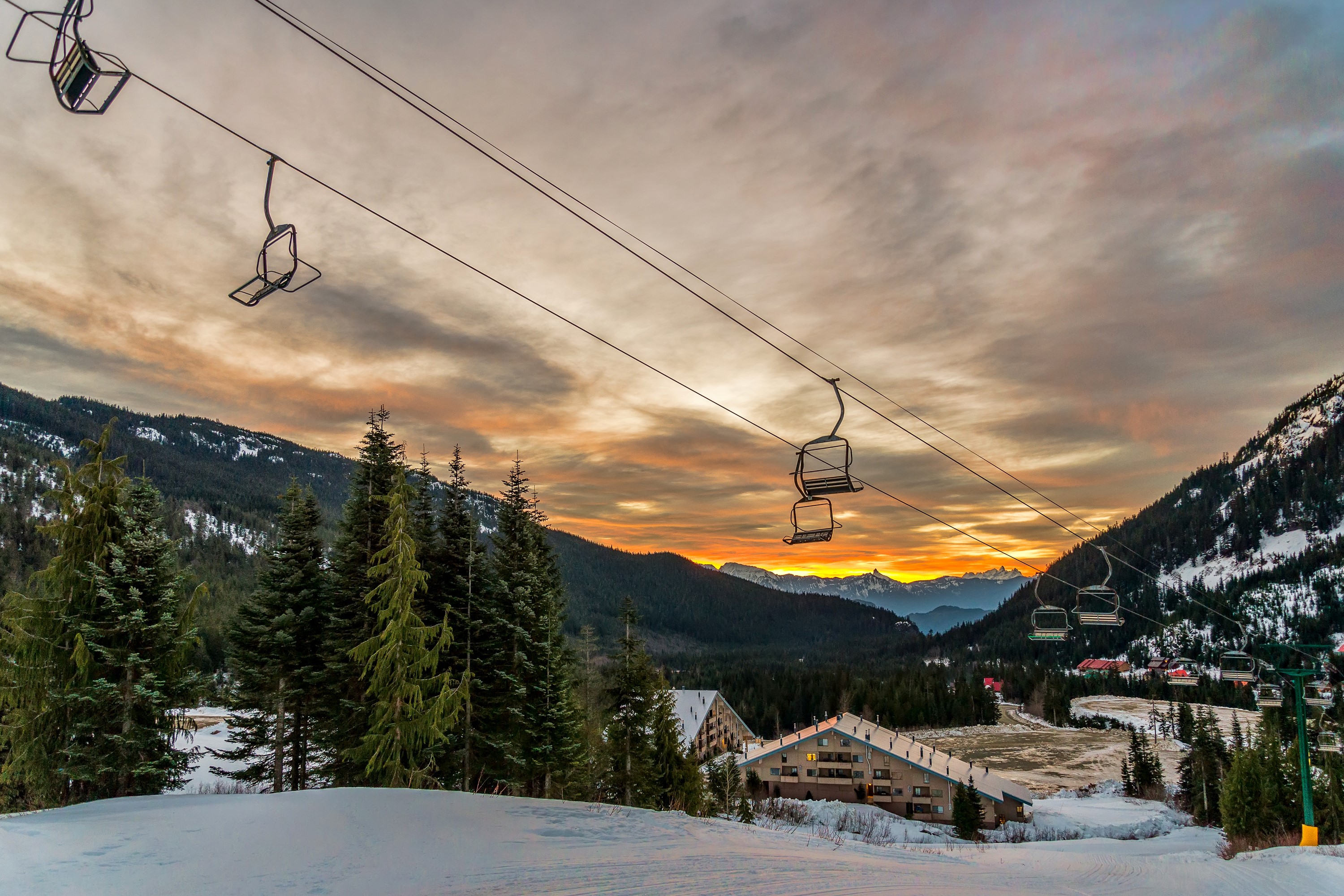 Ski resort with chairlifts at sunset in Canada HD Wallpaper