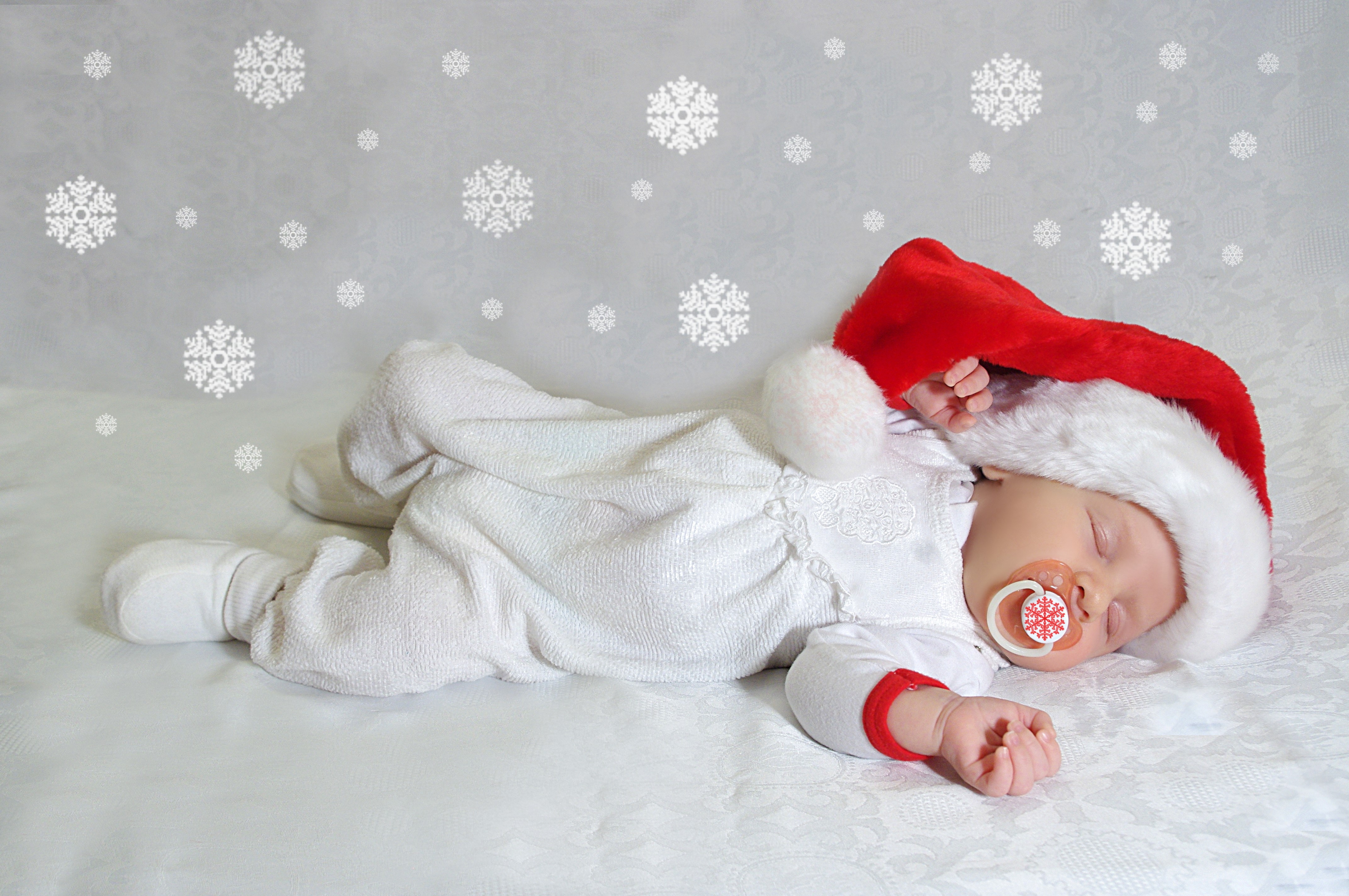 Baby sleeping in Santa hat with snowflakes HD Wallpaper