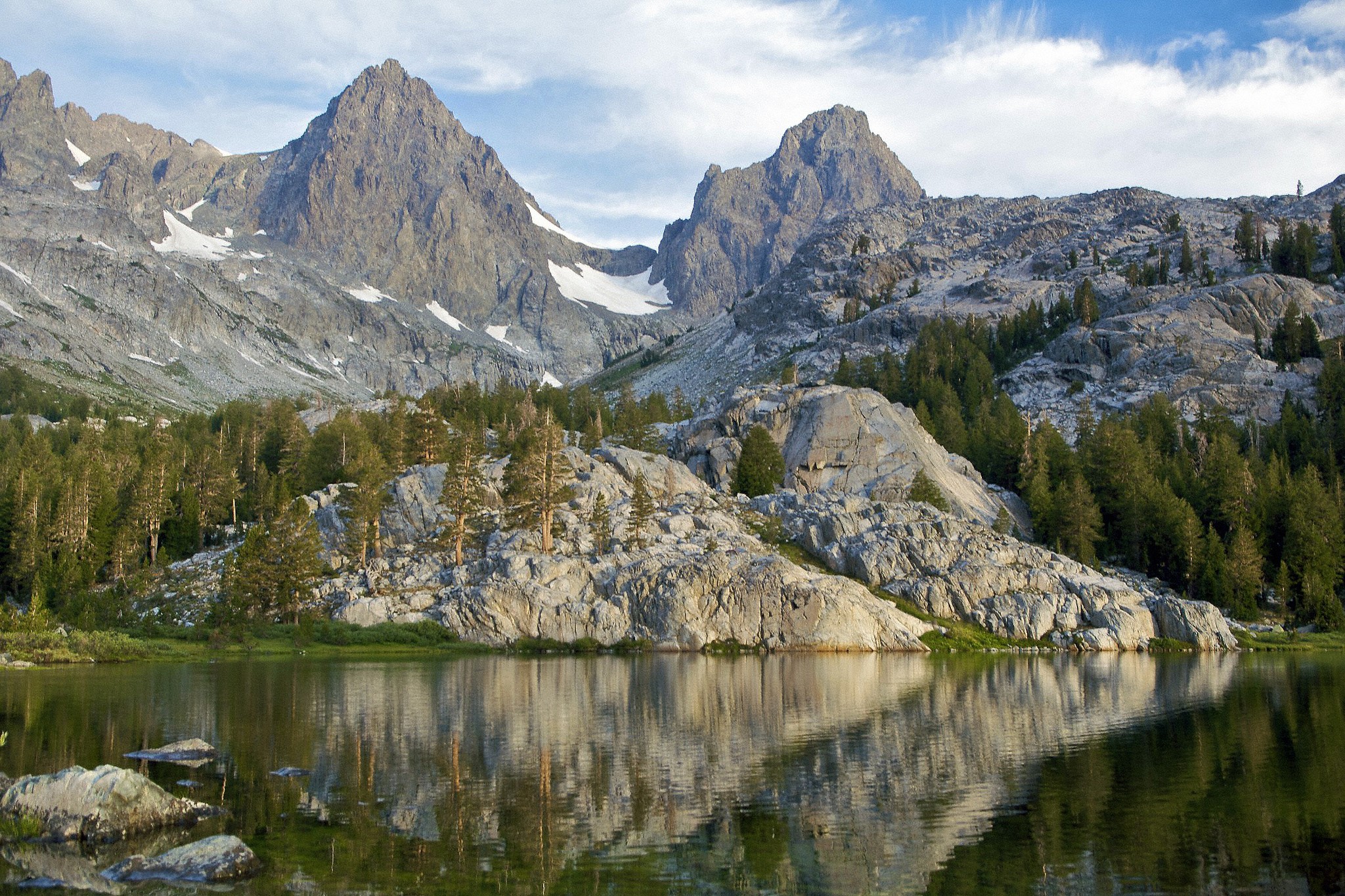 Mountains reflected in a lake with pine trees HD Wallpaper