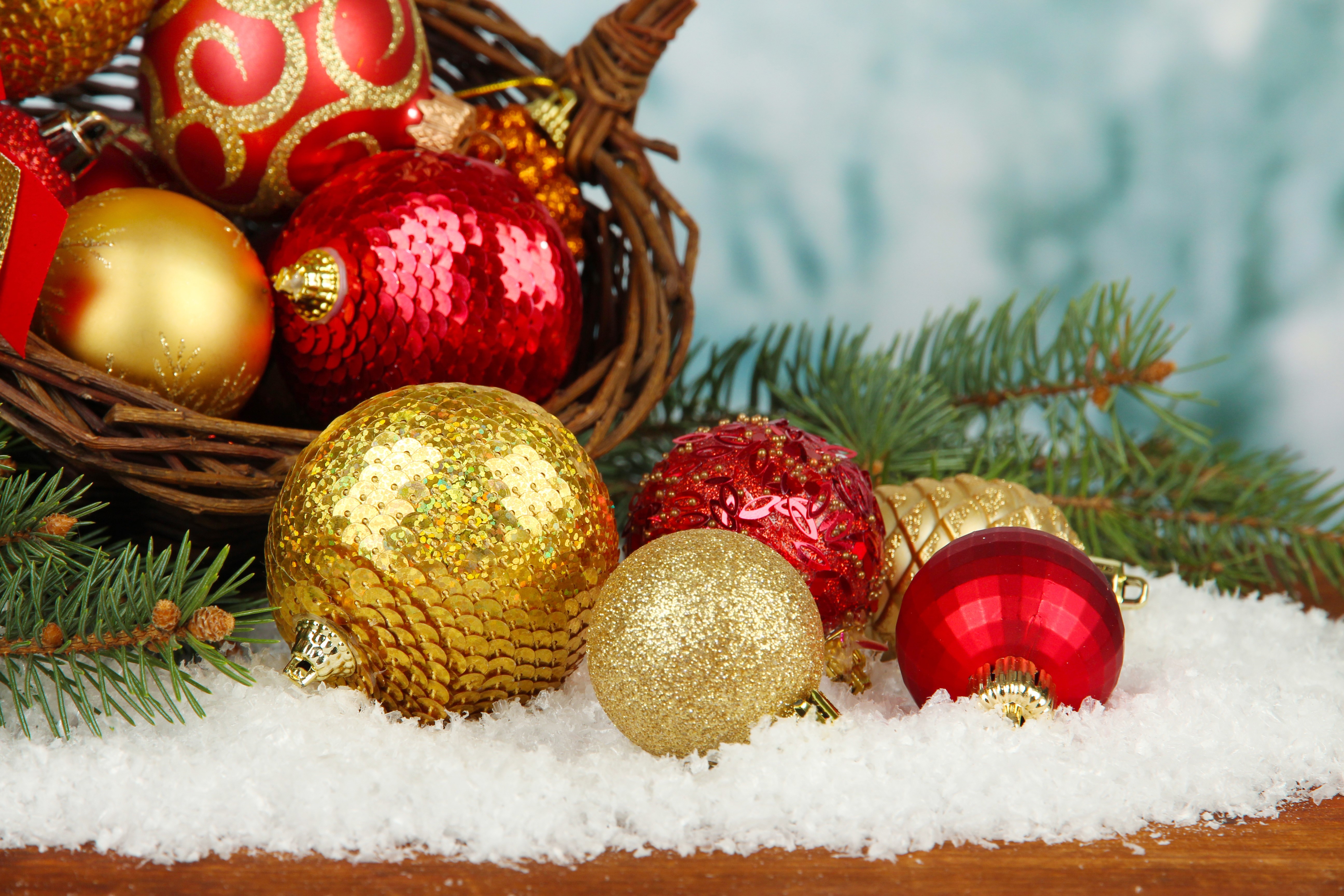 Christmas ornaments in a wicker basket with snow and pine branches HD Wallpaper