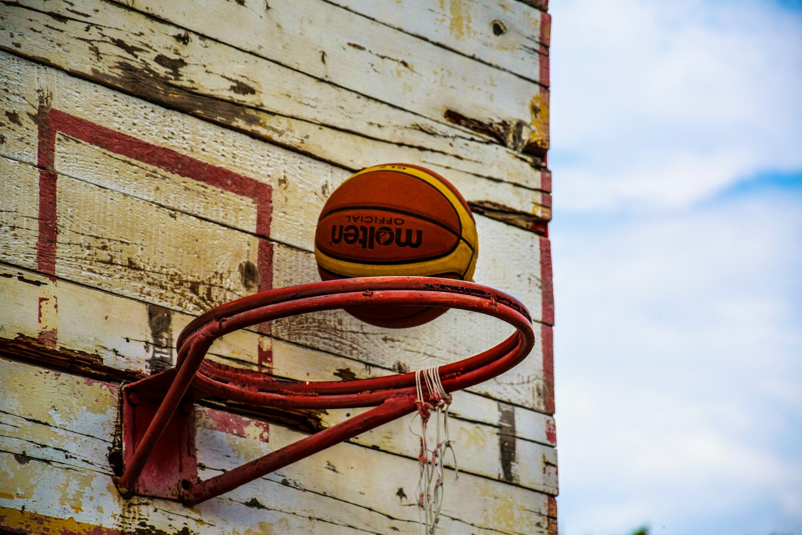 Basketball on a weathered hoop and backboard HD Wallpaper