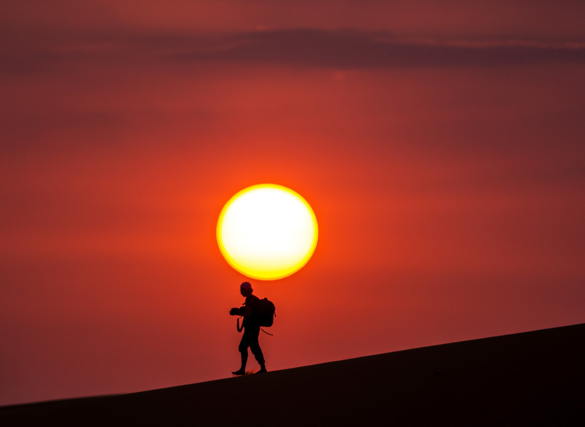 Silhouette of a man walking in the desert at sunset HD Wallpaper