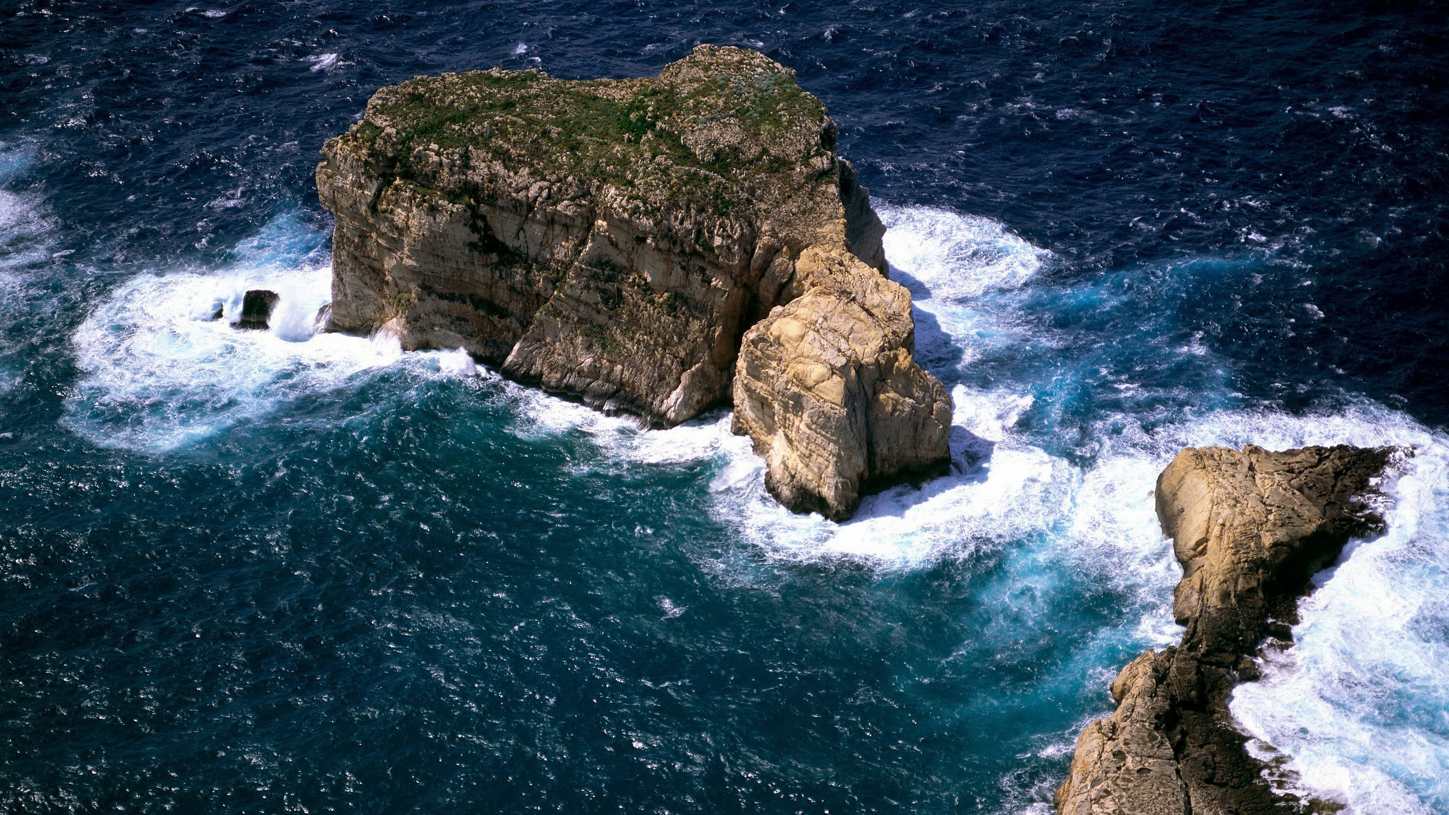 Rocky islands in the ocean with waves crashing HD Wallpaper
