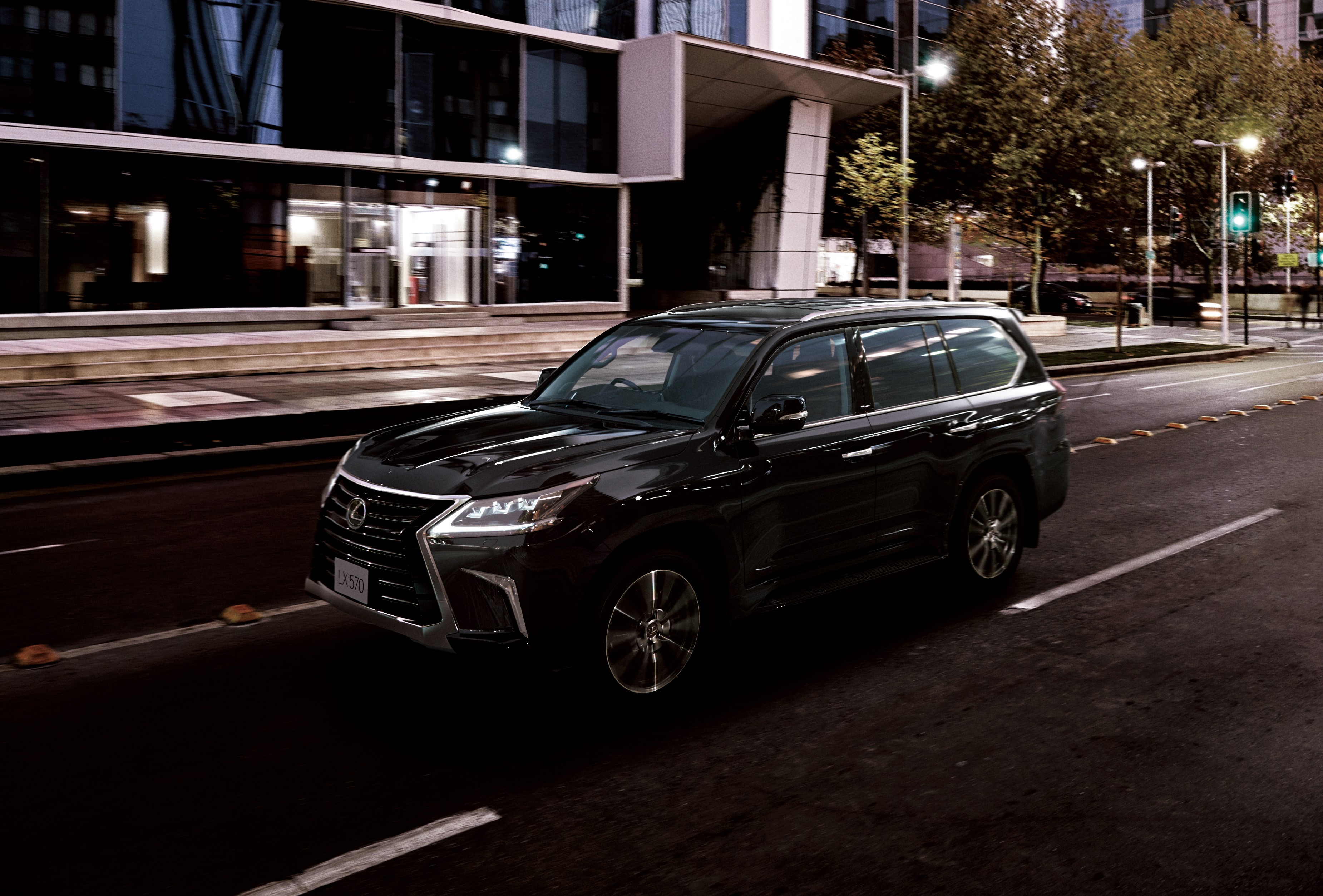 Black Lexus LX 570 driving on a city street at night HD Wallpaper