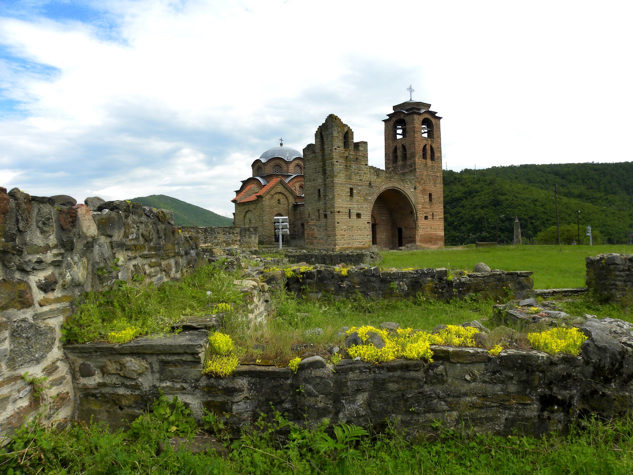 Ruins of a stone church and bell tower in a grassy field HD Wallpaper