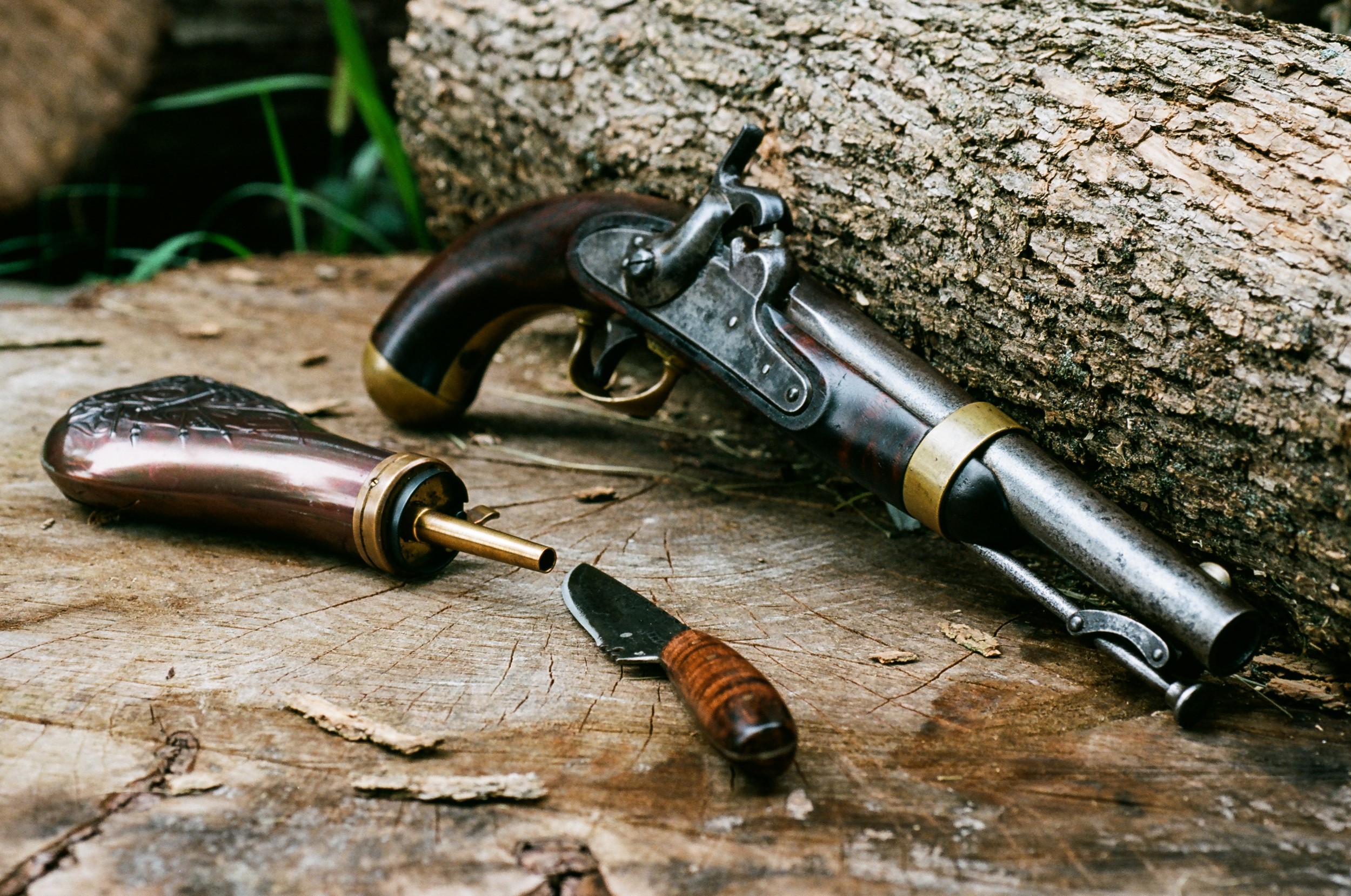 Antique pistol, powder horn, and knife on wood HD Wallpaper