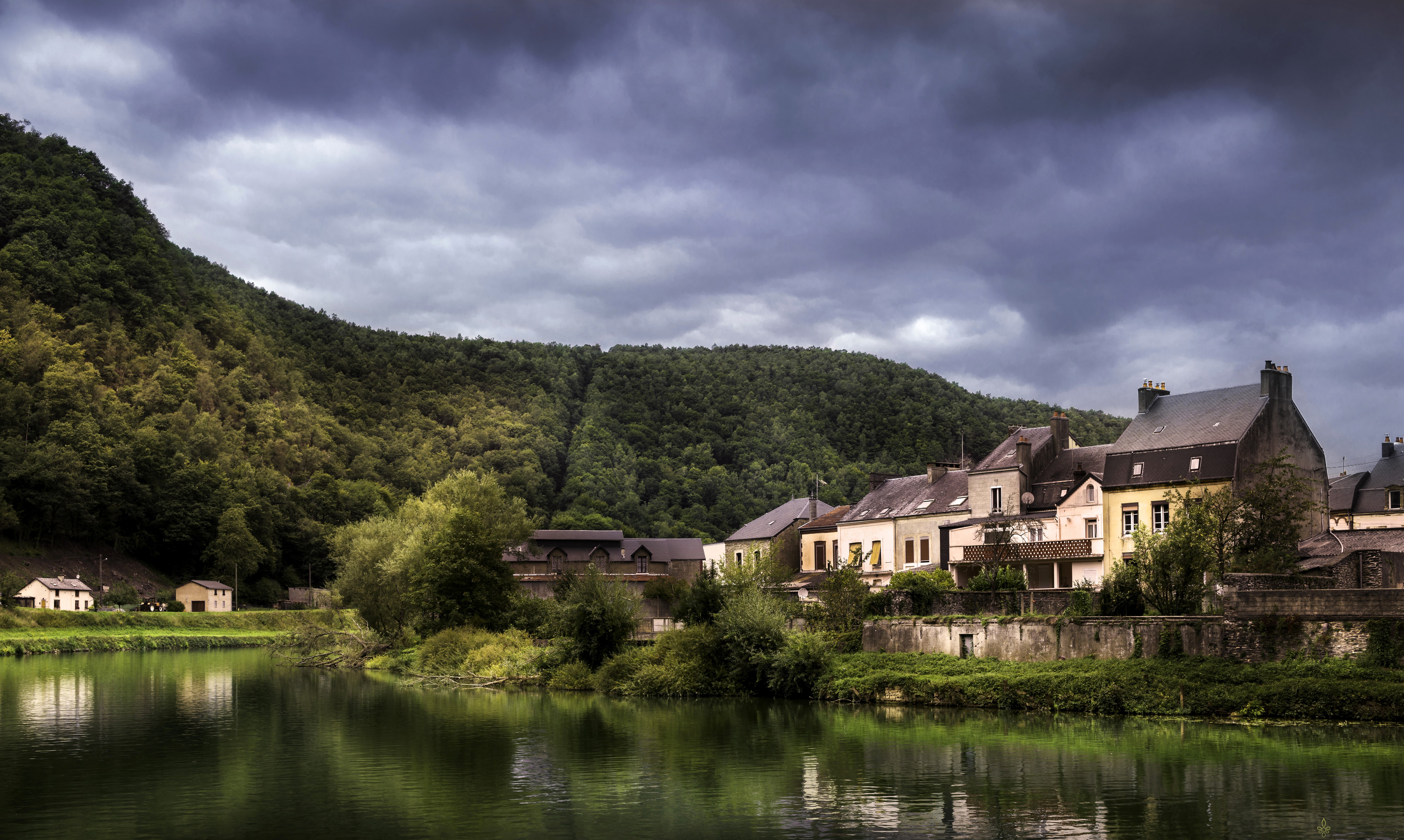 Houses by a river and forest in Revin, France HD Wallpaper