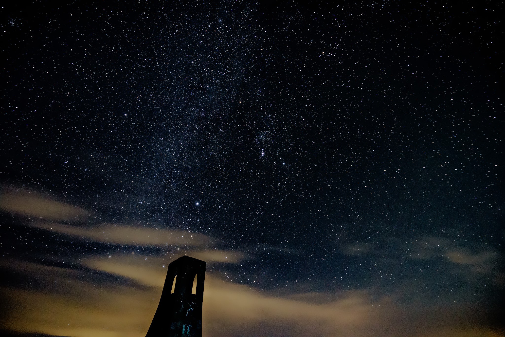 Night sky full of stars over a dark structure HD Wallpaper