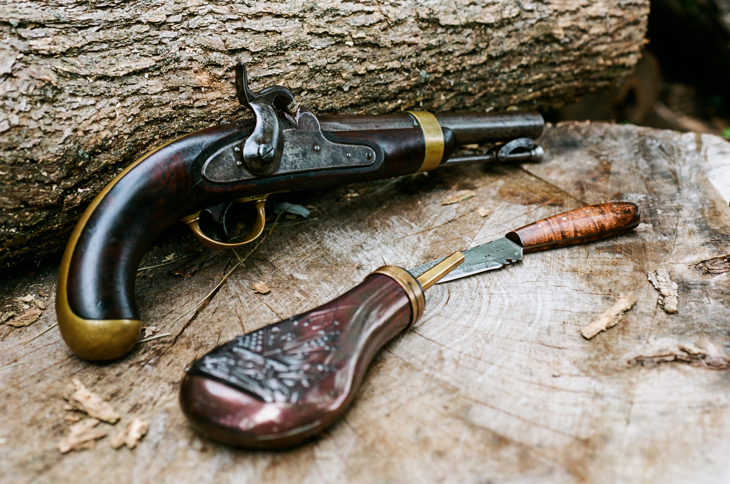 Antique pistol and knife on a log HD Wallpaper