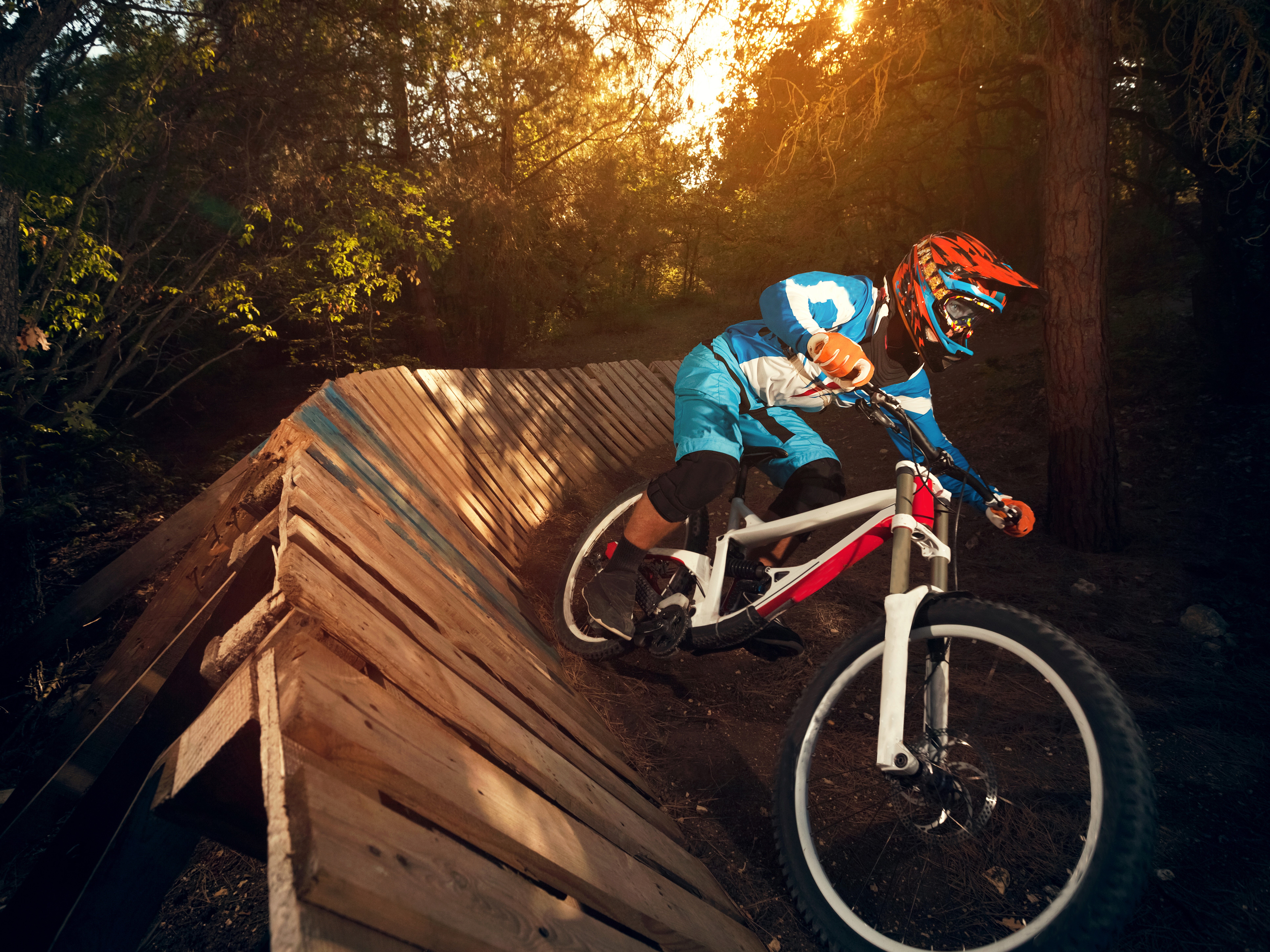 Mountain biker on wooden ramp in forest HD Wallpaper