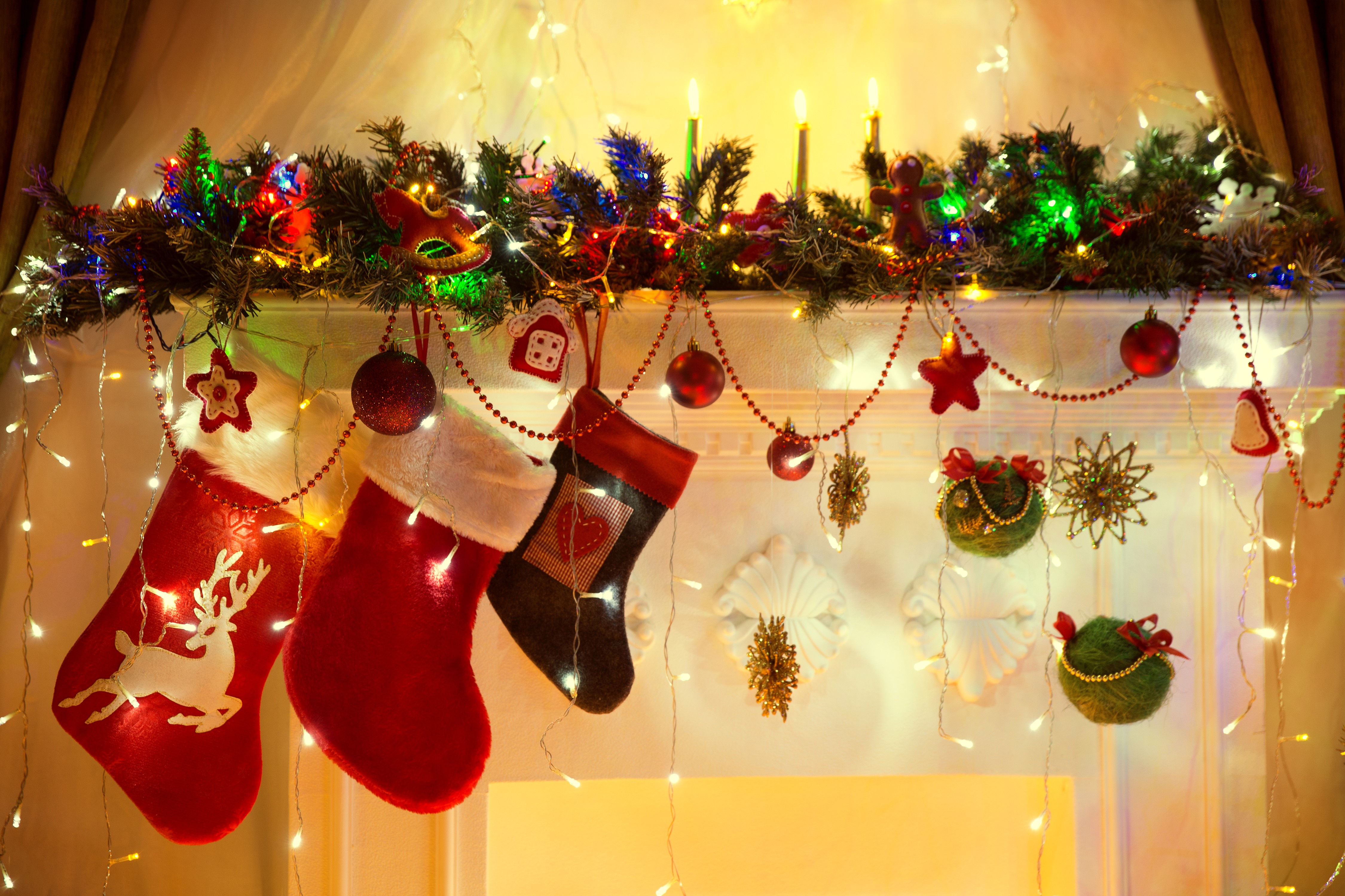 Christmas fireplace mantel with stockings and lights HD Wallpaper