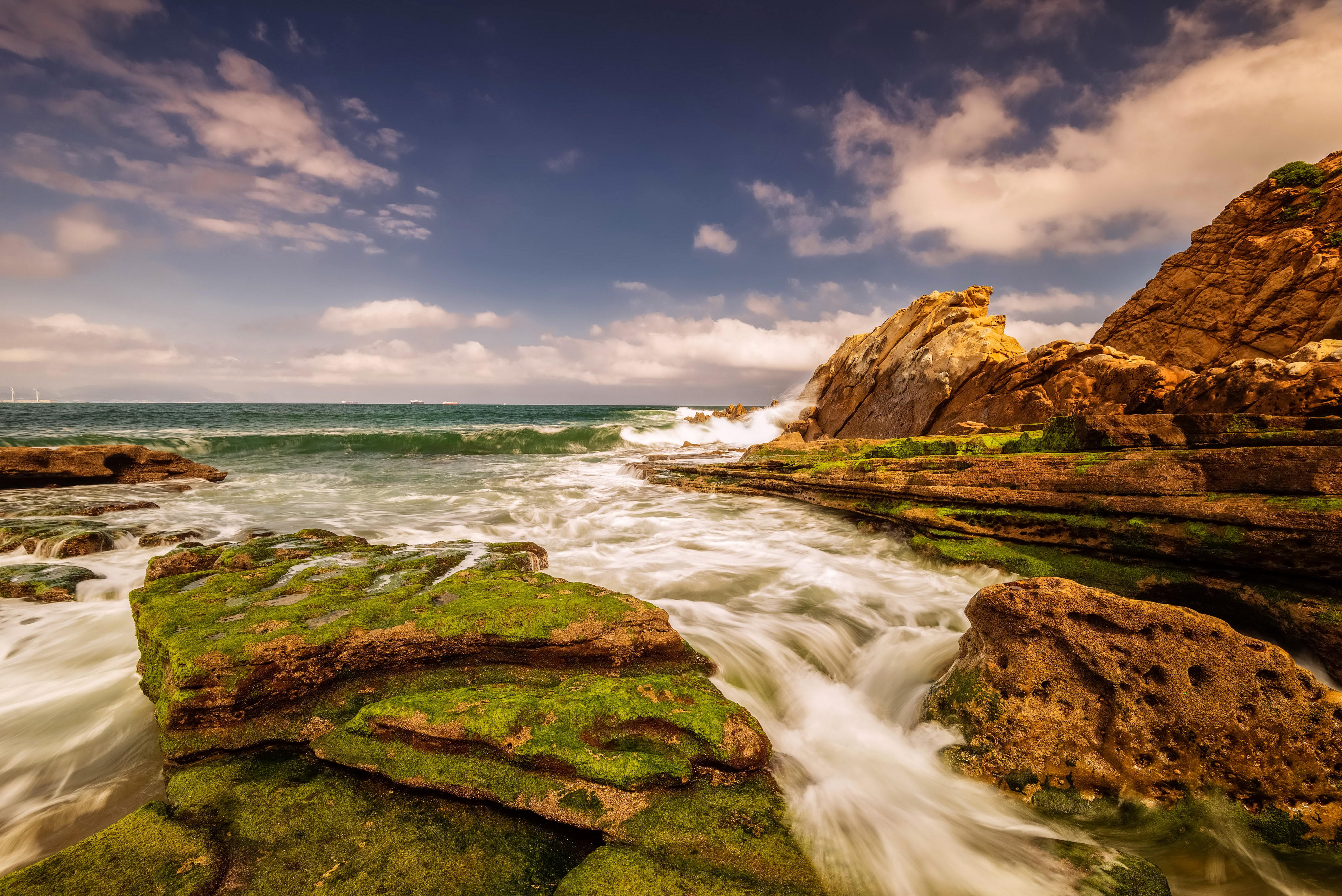 Mossy rocks on a rocky coast with waves HD Wallpaper
