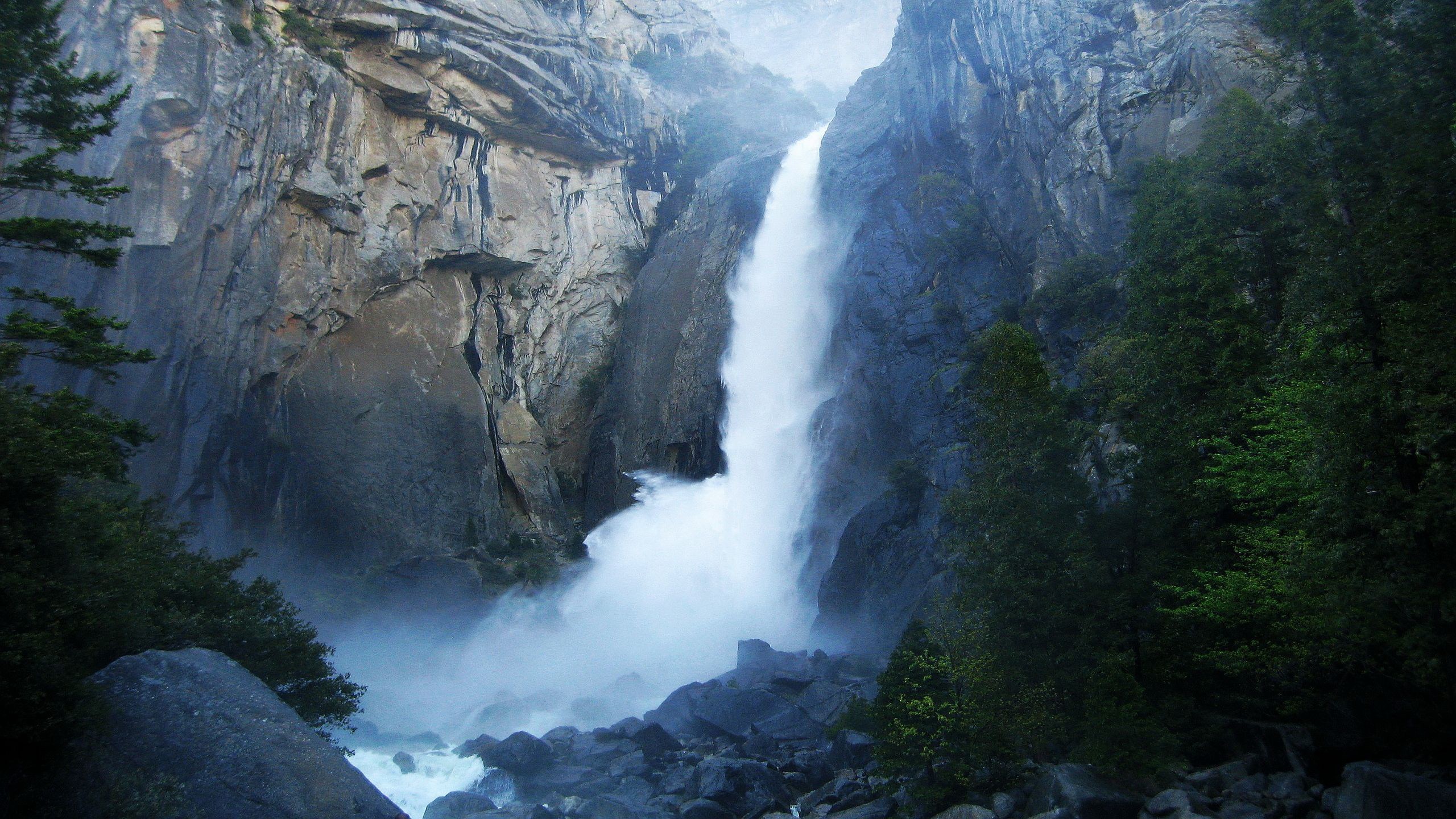 Waterfall cascading down a rocky cliff face HD Wallpaper