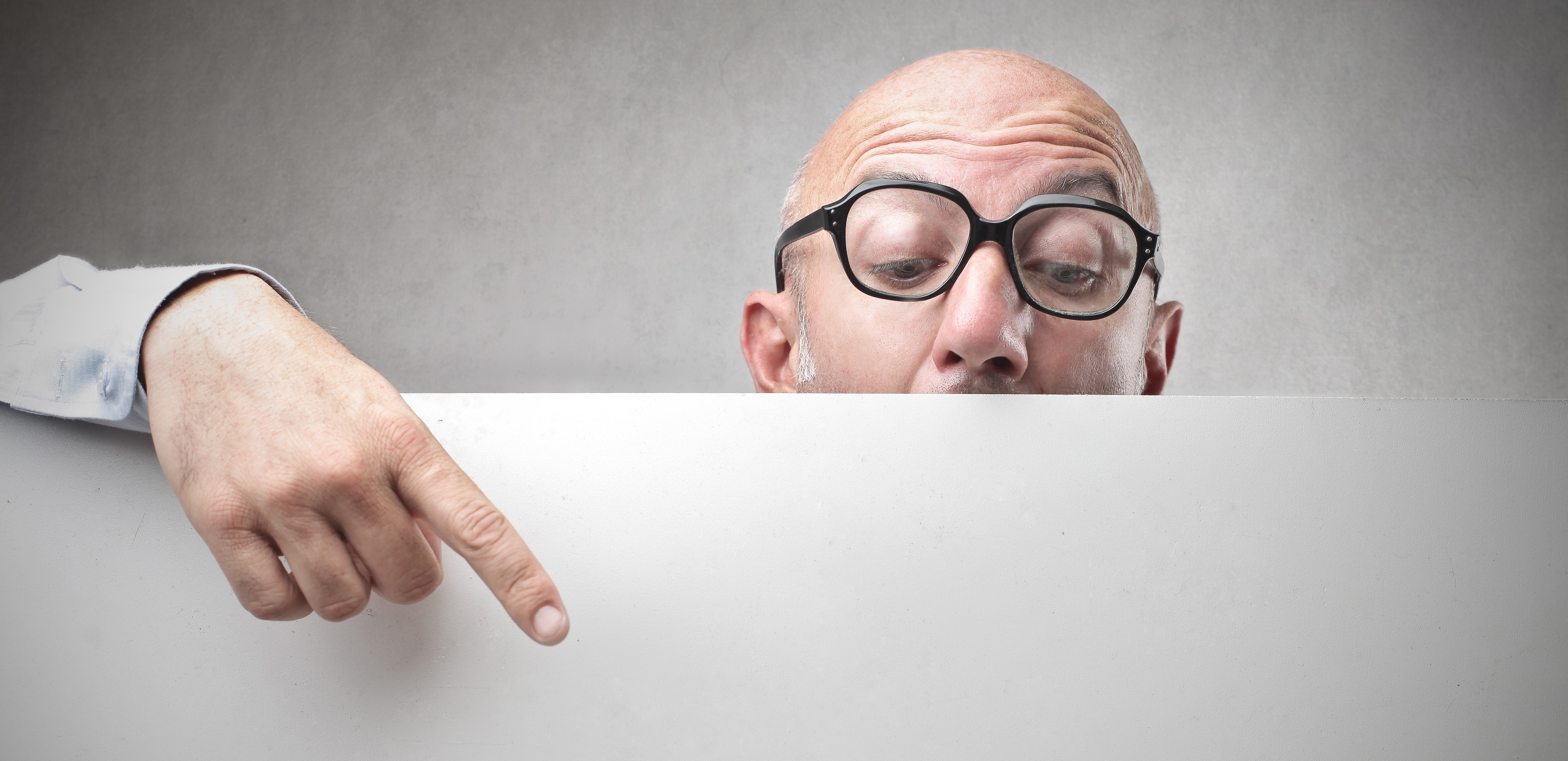 Man wearing glasses pointing at a blank sign HD Wallpaper